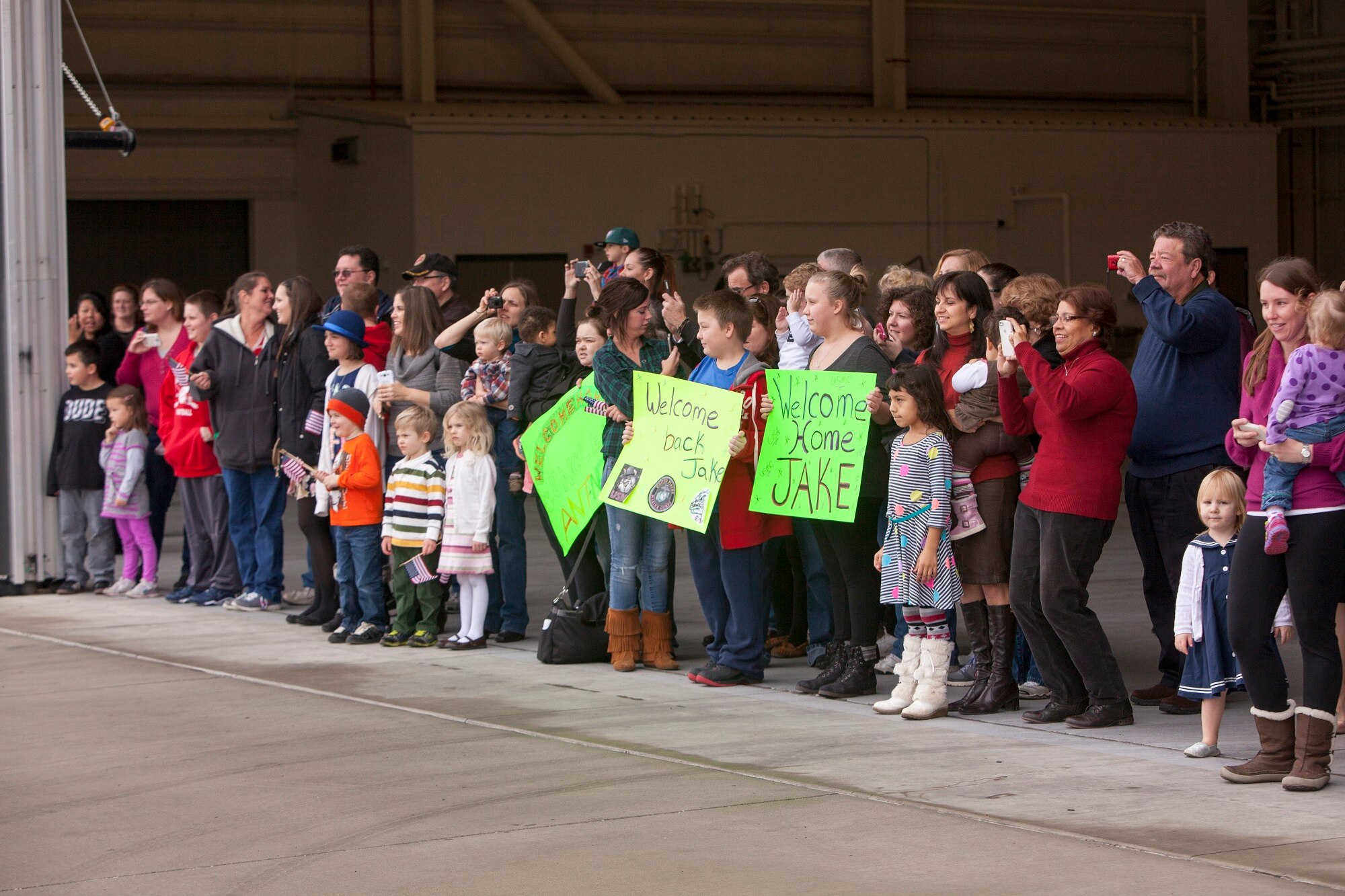 Family and friends gather to welcome home Marines from Marine Heavy Helicopter Squadron (HMH) 772 Detachment 1 from a six-month deployment to Marine Corps Air Station Futenma, Japan, as part of the Marine Forces Reserve's participation in the Unit Deployment Program Dec. 5, 2013, on Joint Base McGuire-Dix-Lakehurst, N.J. The deployment provides necessary training to keep Reserve Marines operationally prepared. (U.S. Air Force photo by Wayne Russell/Released)