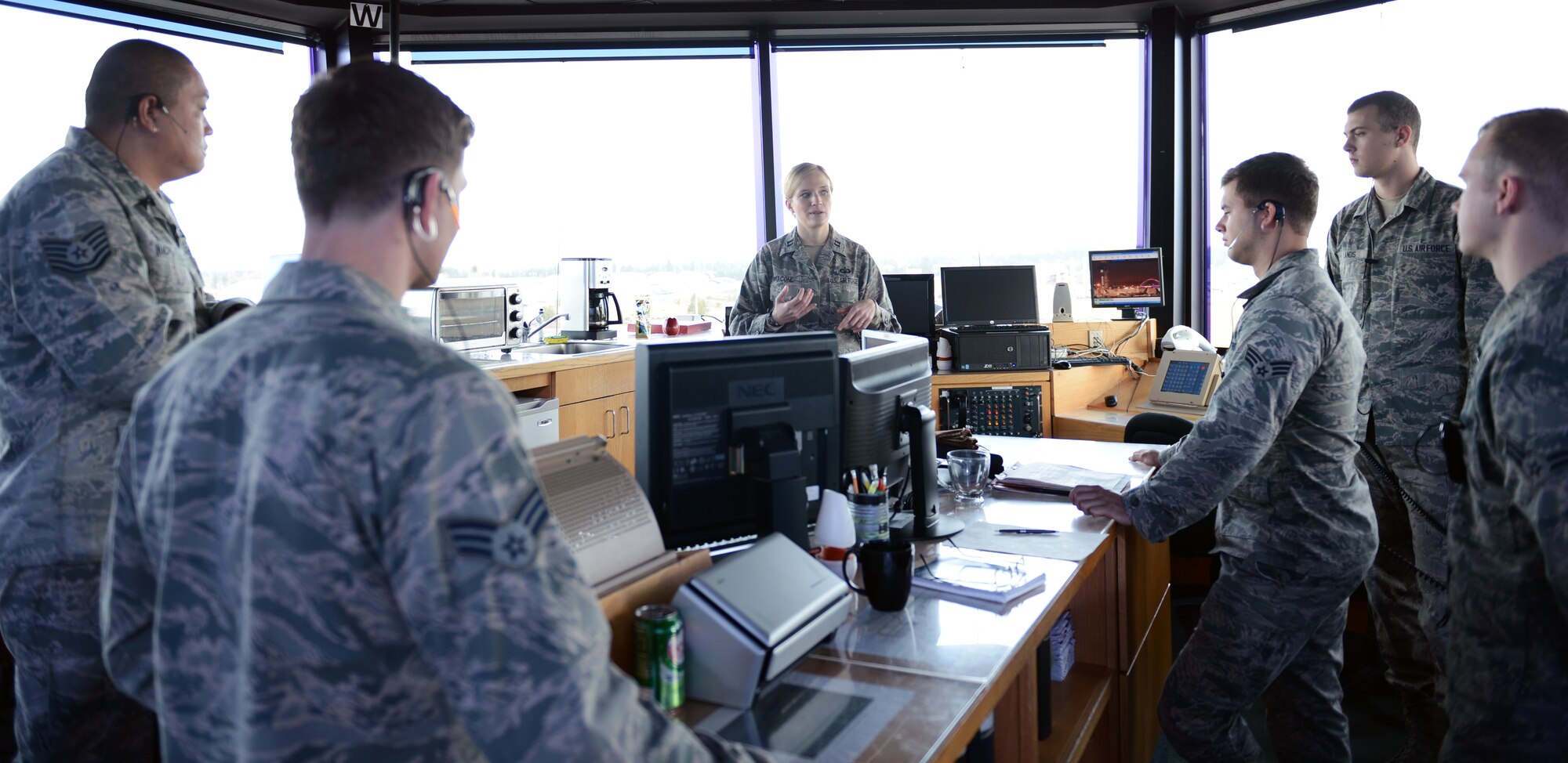 Capt. Rachel Ianacone (center), 62nd Operations Support Squadron airfield operations officer and 62nd Airlift Wing executive officer, talks with air traffic controllers assigned to the 62nd Airlift Wing, Dec. 19 at the McChord Field control tower. Ianacone received an early Christmas present when she notified Dec. 16 that she was selected for the Mansfield Fellowship Program. (U.S. Air Force photo/Staff Sgt. Jason Truskowski)
