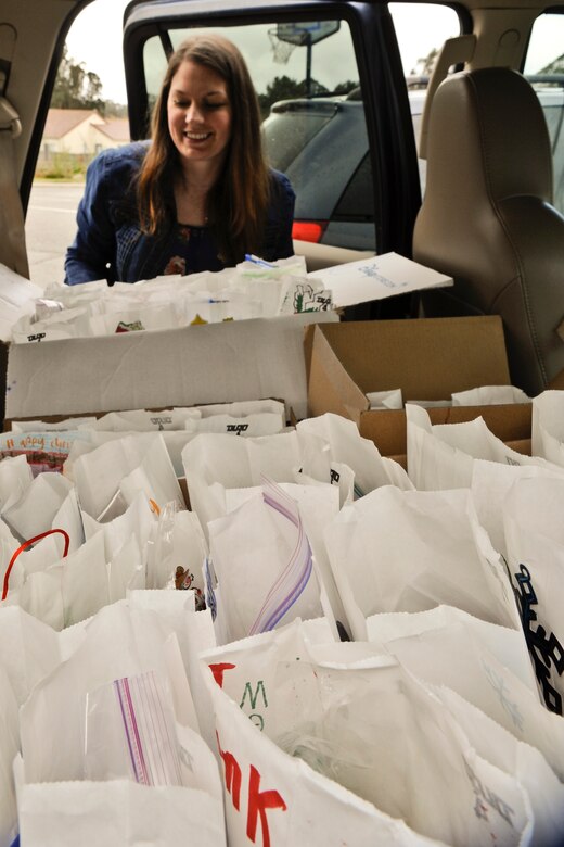 VANDENBERG AIR FORCE BASE, Calif. – Laura King, a member from the Spouses Club, loads donated cookies into a car here Dec. 20, 2013. Cookies baked by spouses and military members around base were put into bags decorated by Crestview and homeschooled children. The Holiday Cookie Express, which started more than 12 years ago, gives Airmen warm smiles and cookies during the holiday season. (U.S. Air Force photo/ Airman 1st Class Yvonne Morales)