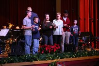Audience members volunteer to get on stage and play a holiday song with the Air Force Band of the West Dec. 17 at the Joint Base San Antonio-Lackland Bob Hope Theater. (U.S. Air Force photo by Airman 1st Class Lincoln Korver)