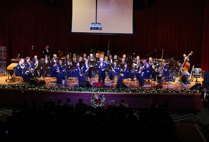 Air Force Capt. Joseph Hansen, Air Force Band of the West deputy commander and conductor, explains the story behind the pieces performed Dec. 17 at the Joint Base San Antonio-Lackland Bob Hope Theater. (U.S. Air Force photo by Airman 1st Class Lincoln Korver)