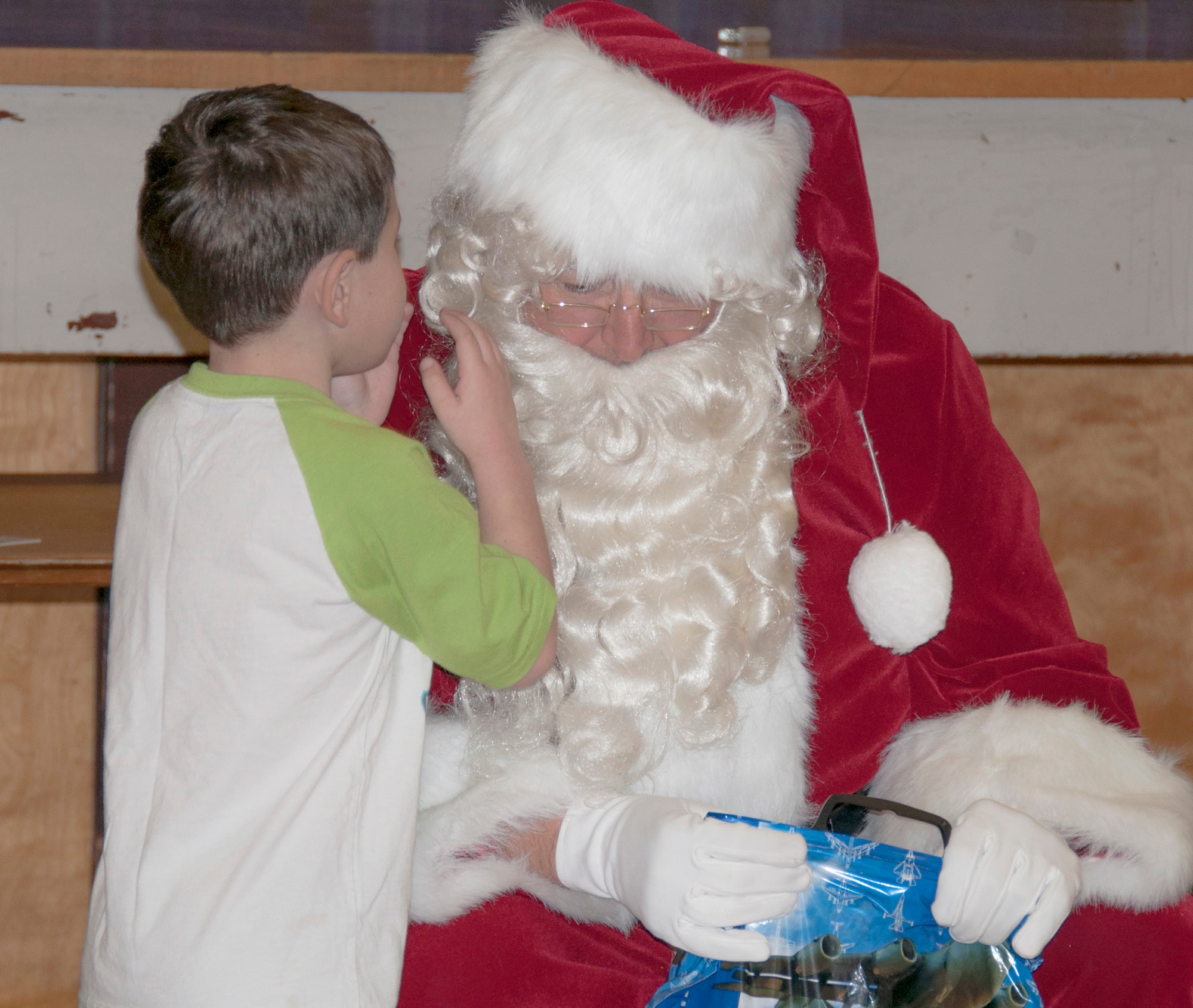 TRAVIS AIR FORCE BASE, Calif. -- For nearly three decades, members of Team Travis have been participating in Operation Teddy Bear. This year, the 349th Medical Group hosted the event and had more than 25 volunteers. Airmen visited local Solano County kindergarten children and distributed 480 gift bags filled with Teddy bears, candy canes, juice boxes, toys, and pencils. The children also got an unexpected surprise; a visit from Santa himself. Chief Master Sgt. Louis Kloeppel, or as he's known to the children, "Santa," listened as each child whispered their Christmas gift wishes in his ear. (U.S. Air Force photo/Staff Sgt. Amelia Leonard)