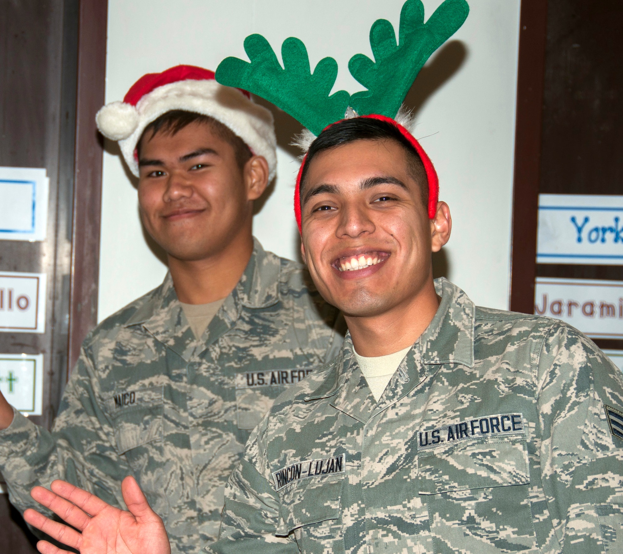 TRAVIS AIR FORCE BASE, Calif. -- Airman Leonel Rincon-Lujan and Senior Airman Michael Maico, 349th Aeromedical Staging Squadron, play the part of Santa's elves as they prepare to pass out bags of goodies in support of Operation Teddy Bear to Cleo Gordon Elementary School kindergartners on Dec. 17,2013. This year, the 349th Medical Group hosted the event and had more than 25 volunteers. Airmen visited local Solano County kindergarten children and distributed 480 gift bags filled with Teddy bears, candy canes, juice boxes, toys, and pencils. (U.S. Air Force photo/Staff Sgt. Amelia Leonard)
