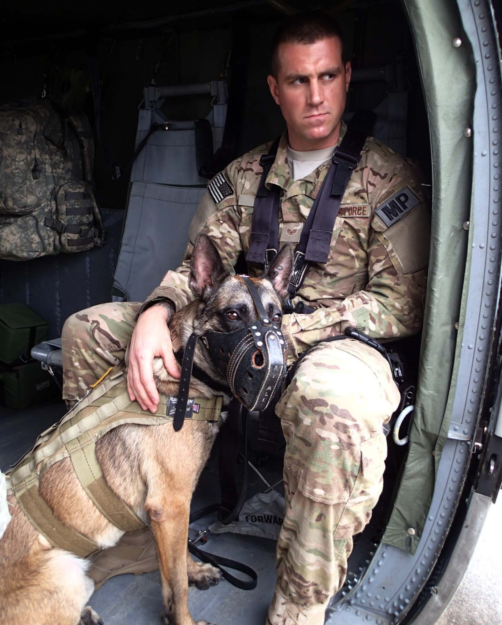 U.S. Air Force Staff Sgt. Ryan Kelly, a military working dog handler assigned to Joint Task Force-Bravo's Joint Security Forces (JSF), sits in the cabin of a UH-60 Blackhawk helicopter with his dog during a medical evacuation (MEDEVAC) familiarization exercise at Soto Cano Air Base, Honduras, Dec. 19, 2013.  Joint Task Force-Bravo’s Medical Element (MEDEL) teamed up with the 1- 228th Aviation Regiment and JSF to conduct the exercise to familiarize the dogs and their handlers in MEDEVAC procedures in case the dogs ever require an emergency medical evacuation. (Photo by U.S. Army Sgt. Jennifer Shick)