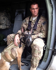 U.S. Air Force Staff Sgt. Ryan Kelly, a military working dog handler assigned to Joint Task Force-Bravo's Joint Security Forces (JSF), sits in the cabin of a UH-60 Blackhawk helicopter with his dog during a medical evacuation (MEDEVAC) familiarization exercise at Soto Cano Air Base, Honduras, Dec. 19, 2013.  Joint Task Force-Bravo’s Medical Element (MEDEL) teamed up with the 1- 228th Aviation Regiment and JSF to conduct the exercise to familiarize the dogs and their handlers in MEDEVAC procedures in case the dogs ever require an emergency medical evacuation. (Photo by U.S. Army Sgt. Jennifer Shick)