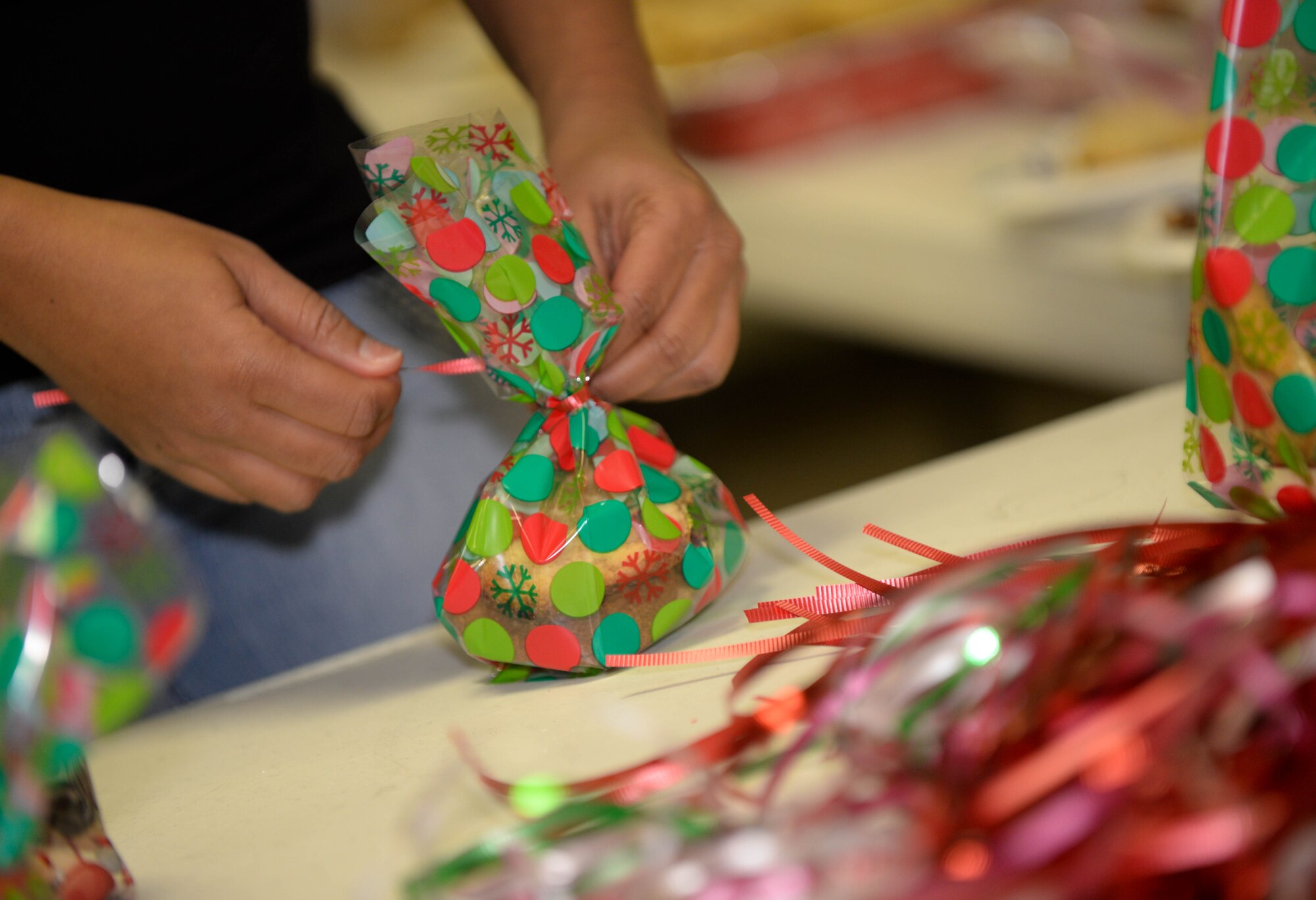 Jamie Mutter, Enlisted Spouses Club secretary, prepares a bag of treats during a holiday cookie drive in the Freedom Chapel at Ellsworth Air Force Base, S.D., Dec. 12, 2013. More than 15 volunteers donated 4,000 cookies and assembled 700 bags for Airmen living in the dormitories. (U.S. Air Force photo by Senior Airman Zachary Hada/Released)