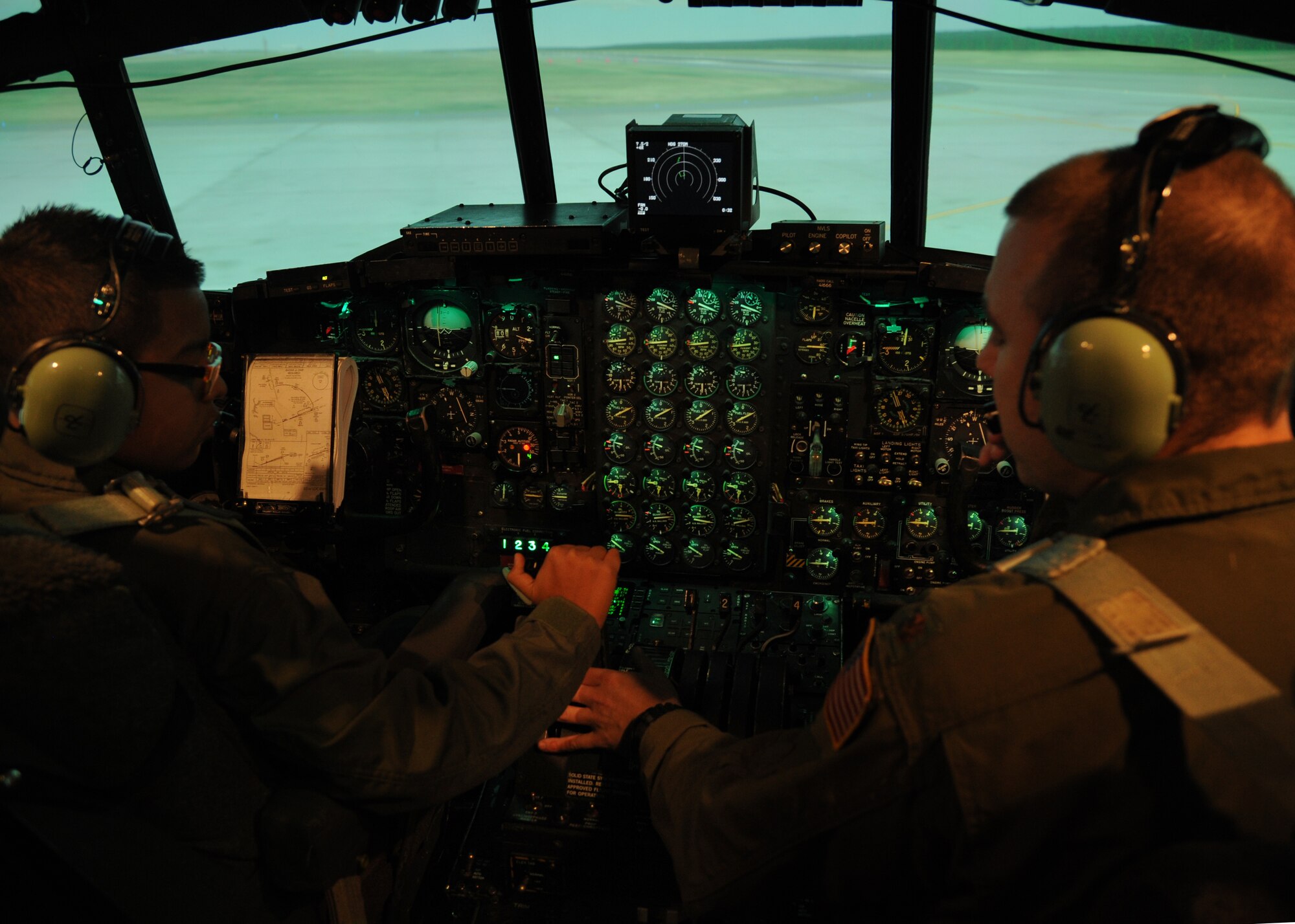 Maj. Jason Oatley, a 714th Training Squadron international military student officer, teaches Alejo Resendiz how to fly a C-130 training simulator Dec. 13, 2013, at Little Rock Air Force Base, Ark. Alejo’s wish of becoming “pilot for a day” came true at The Rock through the Make-A-Wish® foundation. (U.S. Air Force photo by Airman 1st Class Harry Brexel)