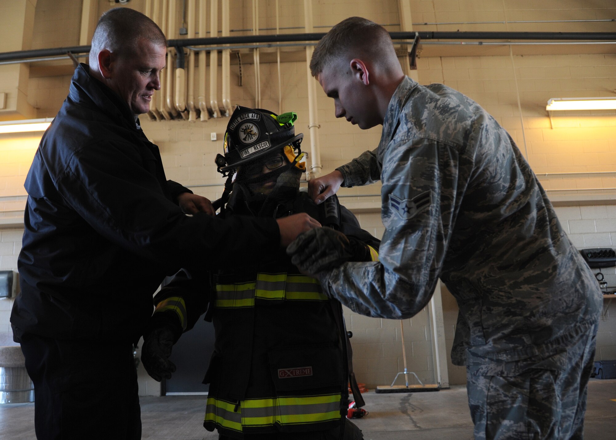 Alejo Resendiz tries on a firefighter suit in the fire department Dec. 13, 2013, at Little Rock Air Force Base, Ark. Alejo toured the fire department as part of his wish to become “pilot for a day” at The Rock, through the Make-A-Wish® foundation. (U.S. Air Force photo by Airman 1st Class Harry Brexel)