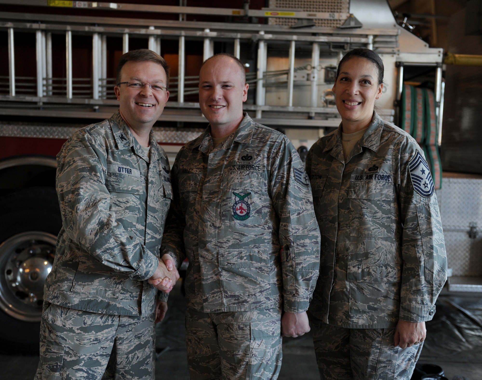 Col. William Otter, 19th Airlift Wing vice commander and Chief Master Sgt. Margarita Overton, 19th AW command chief, congratulate Staff Sgt. Jonathan Hall, a 19th Civil Engineer Squadron Fire Emergency Services Flight accreditation officer, on his selection as Combat Airlifter of the Week Dec. 16, 2013, at Little Rock Air Force Base, Ark.  Hall, a Cincinnati, Ohio native, was recognized for managing the authoring of a 300 page report for his department to receive national accreditation and accomplishing an Air Mobility Command objective. He was also recognized for his help as a volunteer for the Red Cross Disaster Services and developing Airmen at the First Term Airmen’s Center. (U.S. Air Force photo by Staff Sgt. Jessica Condit)