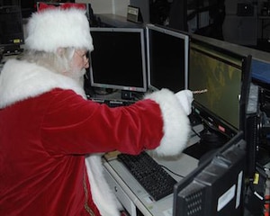 Santa Claus reviews his flight plan for his annual Christmas Eve trek across the globe in the North American Aerospace Defense Command and U.S. Northern Command Current Operations Center at the NORAD and USNORTHCOM headquarters at Peterson Air Force Base, Colo., Sept. 26, 2013. (U.S. Air Force photo/Michael Kucharek)