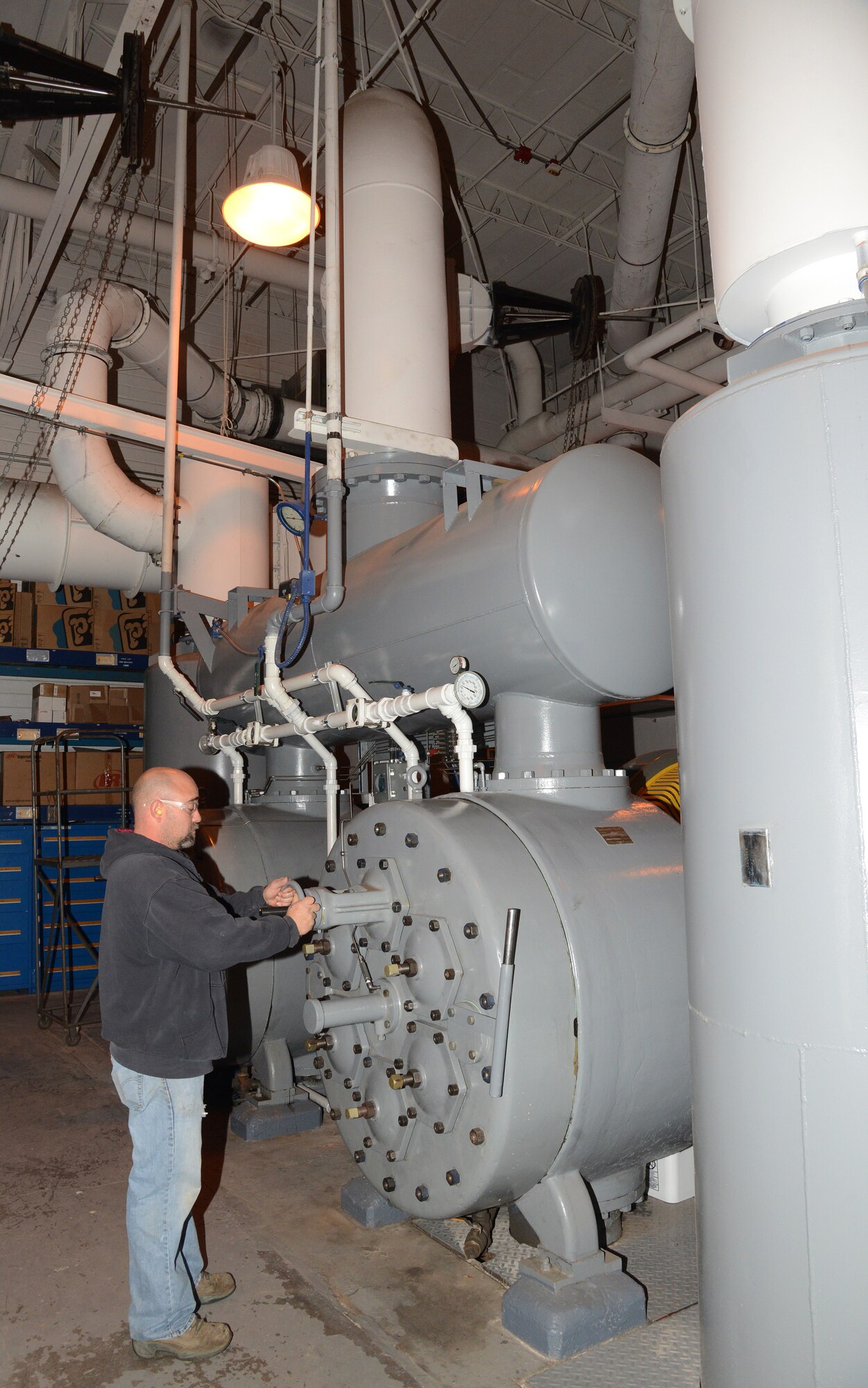 Patrick Duff, a production equipment mechanic in the 76th Maintenance Support Squadron, adjusts valves on the vacuum pump (the “Big Vac”) in Bldg. 210. (Air Force photo by Kelly White)