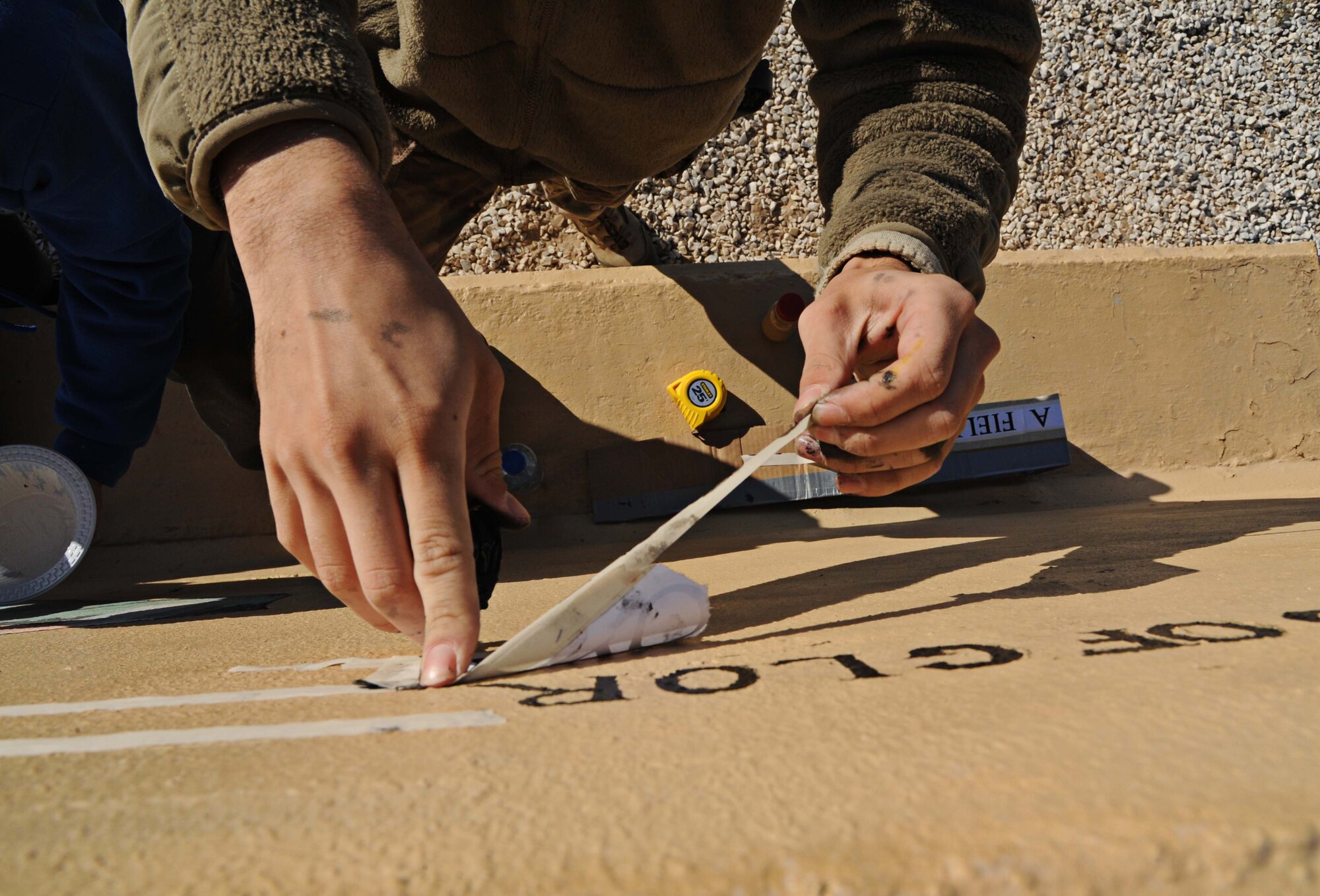 Airman 1st Class Alex Moore, 386th Expeditionary Security Forces Squadron base security, revives a 2005 tribute painting of A1C Elizabeth Jacobson, undisclosed location Southwest Asia. After noticing sun damage and chipped paint Moore decided to resuscitate the beauty it once had. She is the first Security Forces Airman to die in Operation Iraqi Freedom. She is also the first female Airman killed in the line of duty in support of OIF. (U.S. Air Force photo by Senior Airman Desiree W. Moye)