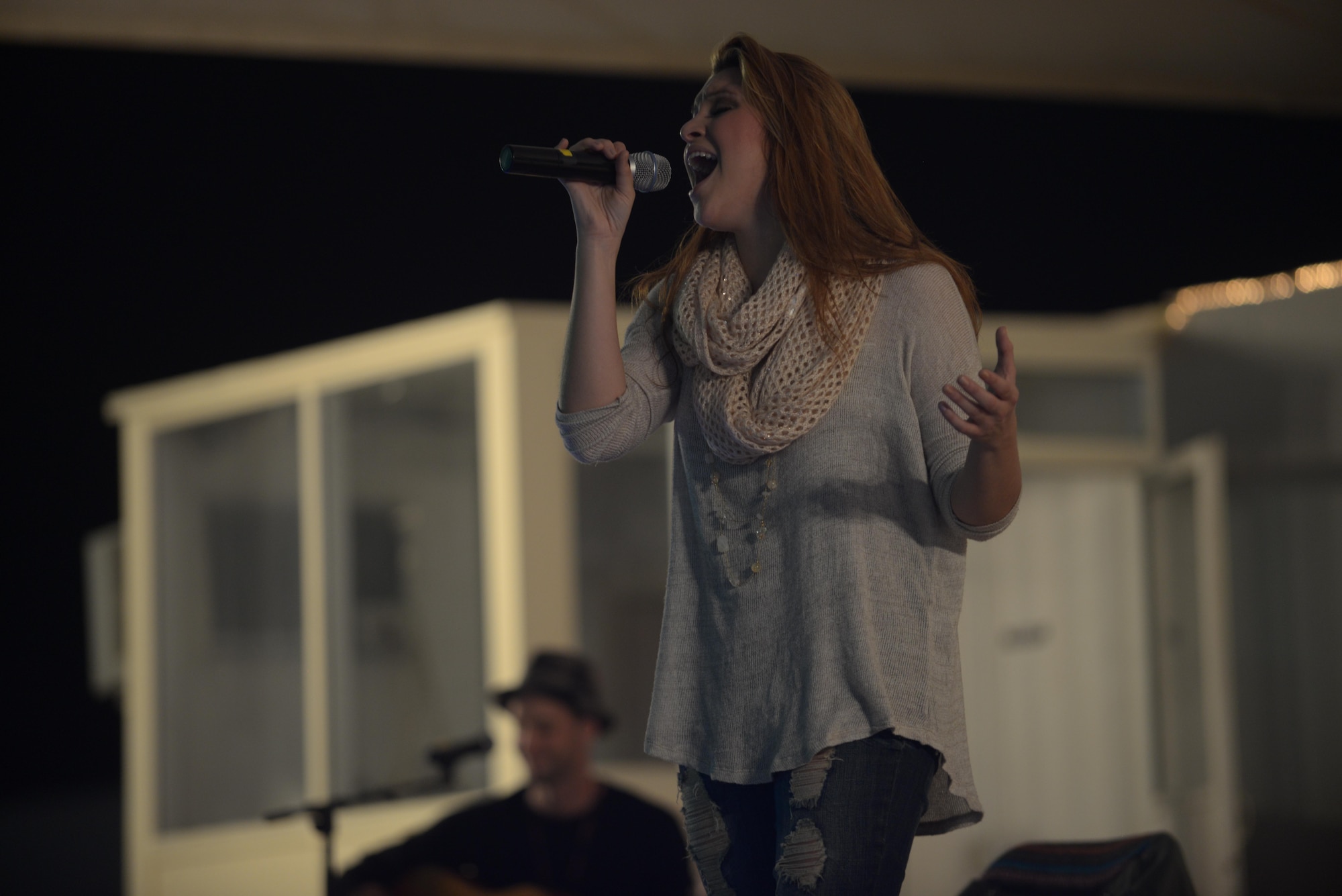Alaina Blair, a country music artist, performs for service members at the 379th Air Expeditionary Wing in Southwest Asia, Dec. 19, 2013.  Blair, along with her band, performed 11 concerts in five countries across the U.S. Air Forces Central Command area of responsibility over an 18 day period. Completing the Armed Forces Entertainment tour here, Blair sang a mix of her own music, cover songs and Christmas carols to the audience, providing an interactive performance while spreading holiday cheer. (U.S. Air Force photo by Master Sgt. David Miller)
