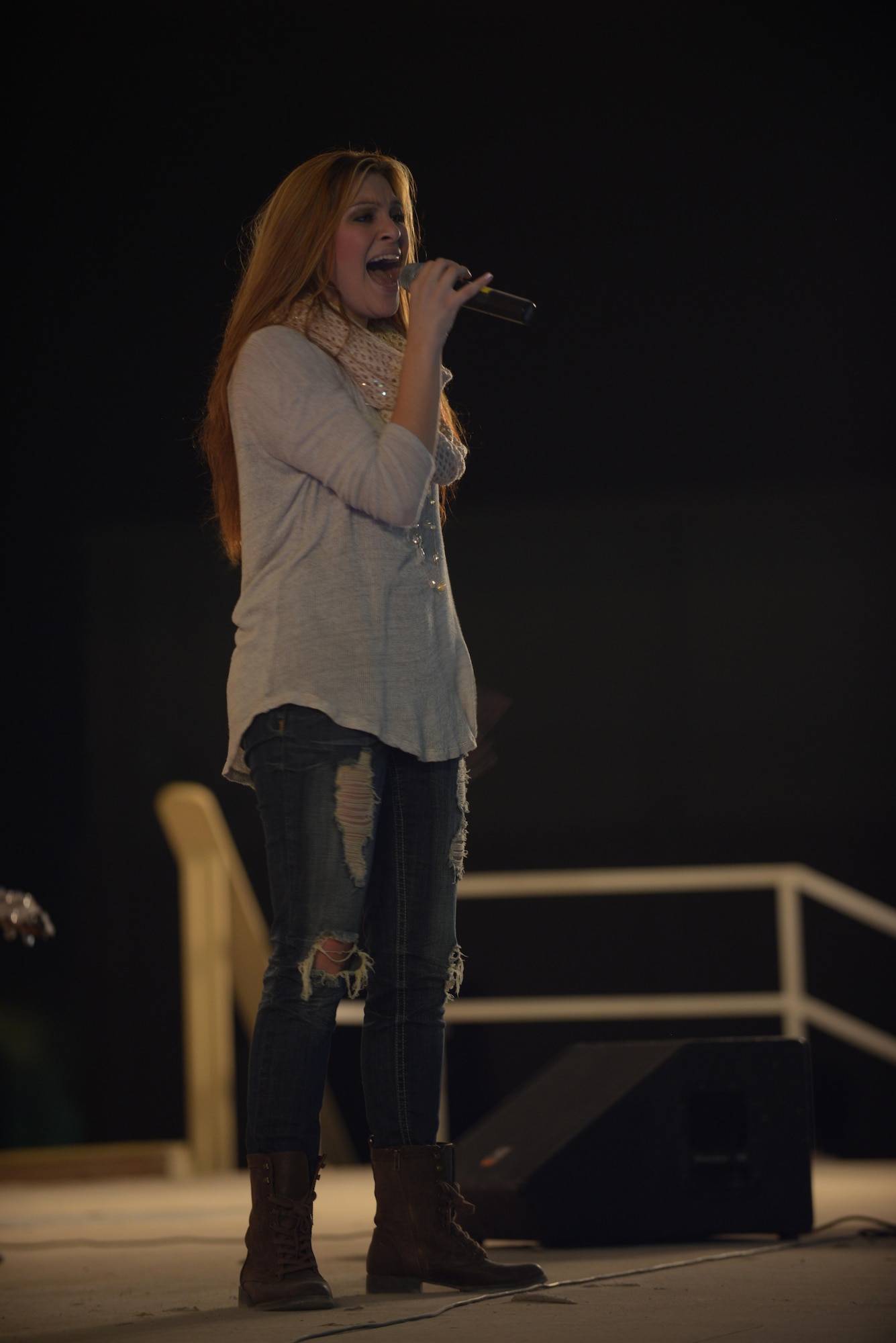 Alaina Blair, a country music artist, performs for service members at the 379th Air Expeditionary Wing in Southwest Asia, Dec. 19, 2013.  Blair, along with her band, performed 11 concerts in five countries across the U.S. Air Forces Central Command area of responsibility over an 18 day period. Completing the Armed Forces Entertainment tour here, Blair sang a mix of her own music, cover songs and Christmas carols to the audience, providing an interactive performance while spreading holiday cheer. (U.S. Air Force photo by Master Sgt. David Miller)