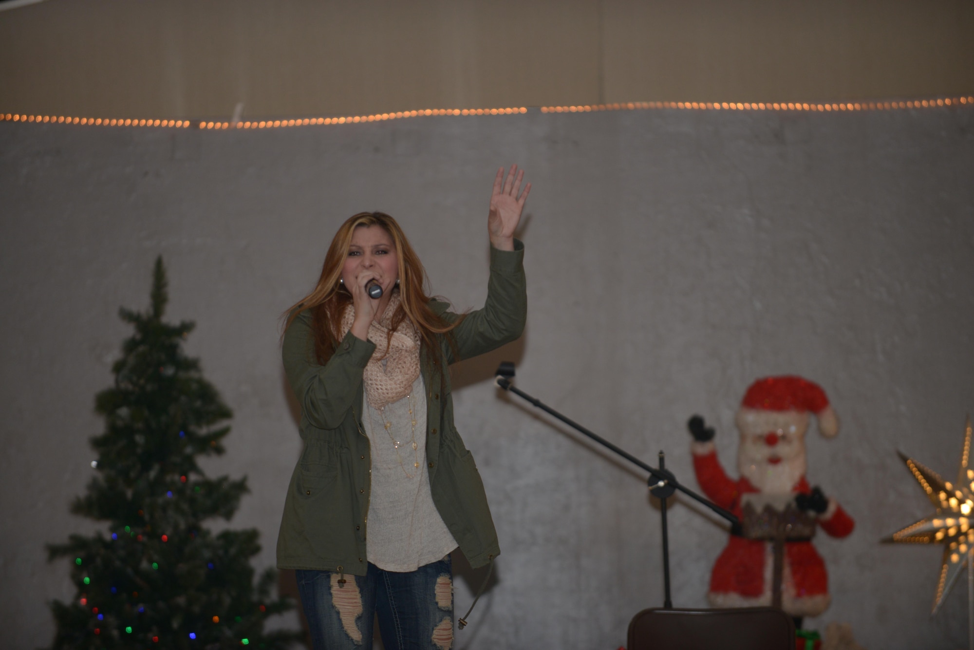 Alaina Blair, a country music artist, performs for service members at the 379th Air Expeditionary Wing in Southwest Asia, Dec. 19, 2013.  Blair, along with her band, performed 11 concerts in five countries across the U.S. Air Forces Central Command area of responsibility over an 18 day period. Completing the Armed Forces Entertainment tour here, Blair sang a mix of her own music, cover songs and Christmas carols to the audience, providing an interactive performance while spreading holiday cheer. (U.S. Air Force photo by Master Sgt. David Miller)