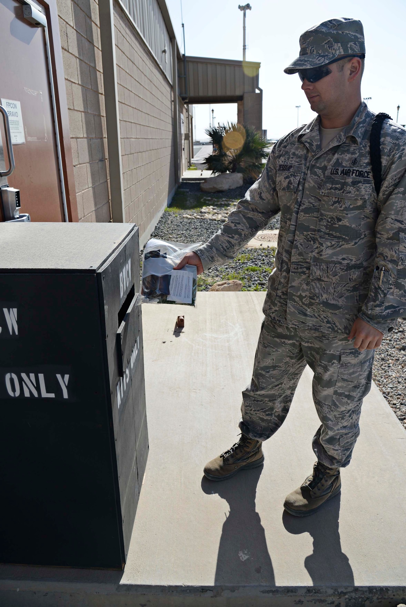 Staff Sgt. Jared Jessup, 386th Expeditionary Medical Group pharmacy technician, utilizes the new amnesty box, undisclosed location Southwest Asia. This initiative benefits two units on The Rock. The pharmacy properly disposes of the Biological and Chemical Warfare antidote kits while EOD completes disposal detonation training. (U.S. Air Force photo by Senior Airman Desiree W. Moye)