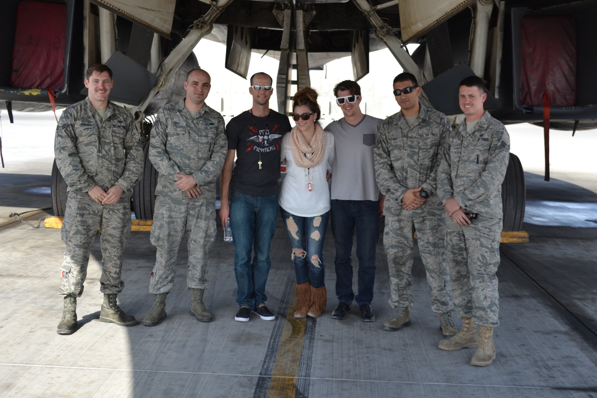 Airmen from the 9th Expeditionary Aircraft Maintenance Squadron pose for a picture with Alaina Blair, a country music artist who performed for service members at the 379th Air Expeditionary Wing in Southwest Asia, Dec. 19, 2013.  Alaina Blair, along with her band, performed 11 concerts in five countries across the U.S. Air Forces Central Command area of responsibility over an 18 day period.  Blair sang a mix of her own music, cover songs and Christmas carols to the audience, providing an interactive performance while spreading holiday cheer.  (U.S. Air Force photo/Maj. Nicole David)