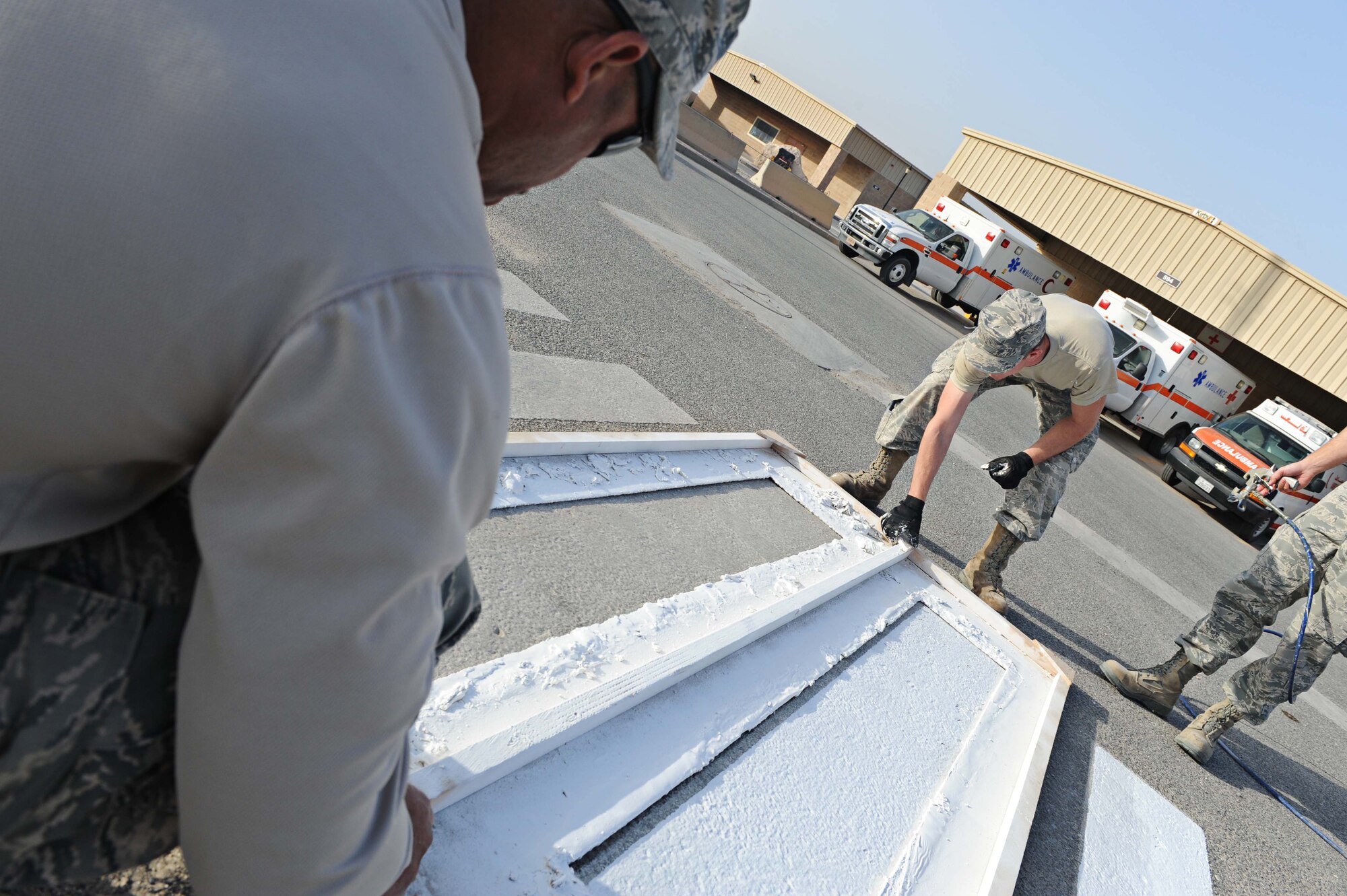 386th Expeditionary Civil Engineer Squadron members paint a distressed crosswalk, undisclosed location Southwest Asia. Base improvements are consistently ongoing on The Rock. (U.S. Air Force photo by Senior Airman Desiree W. Moye)