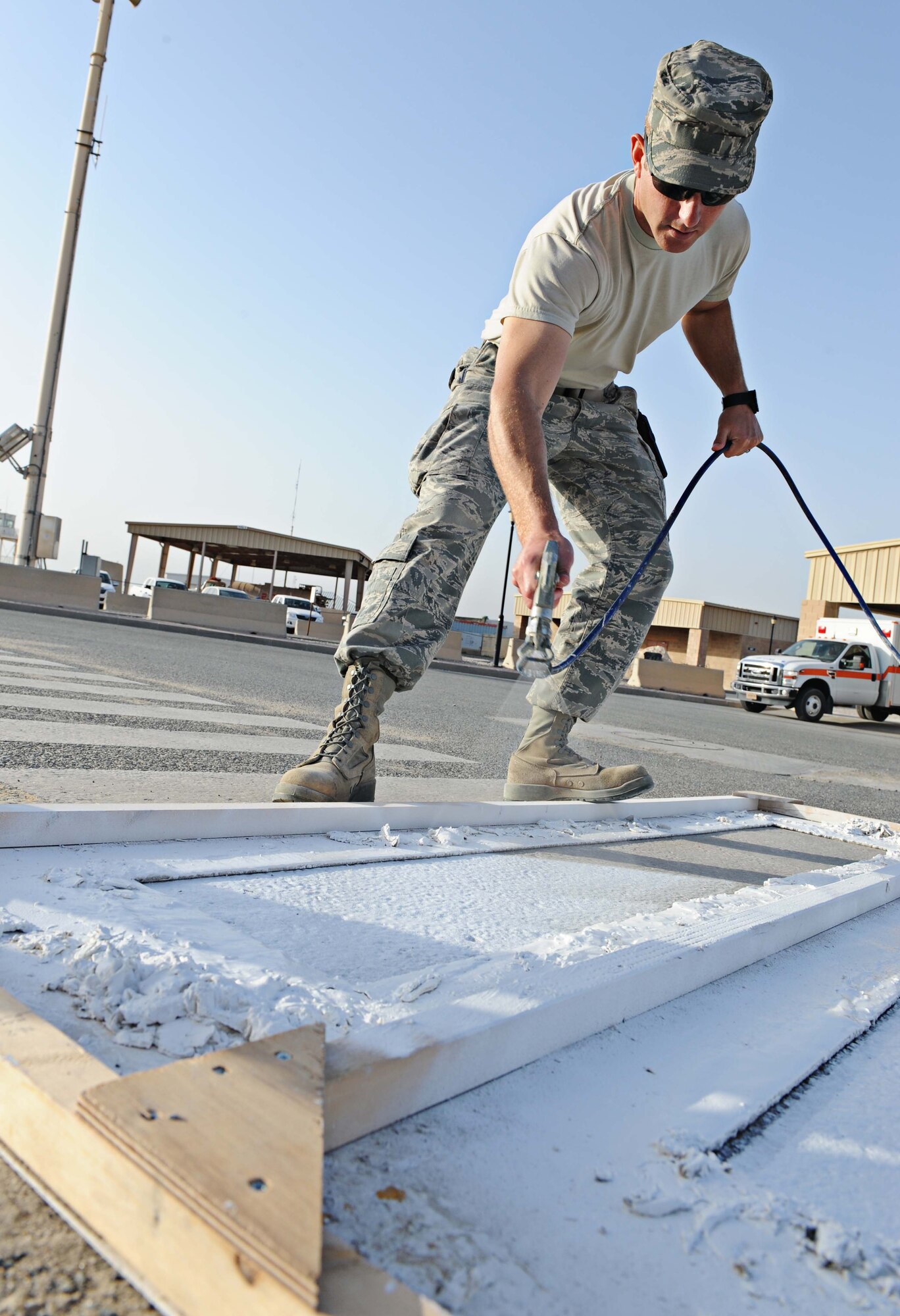 Technical Sgt. Joseph Hodges 386th Expeditionary Civil Engineer Squadron structures journeyman, repaints a pedestrian cross walk, undisclosed location Southwest Asia. Base improvements are consistently ongoing on The Rock. (U.S. Air Force photo by Senior Airman Desiree W. Moye)