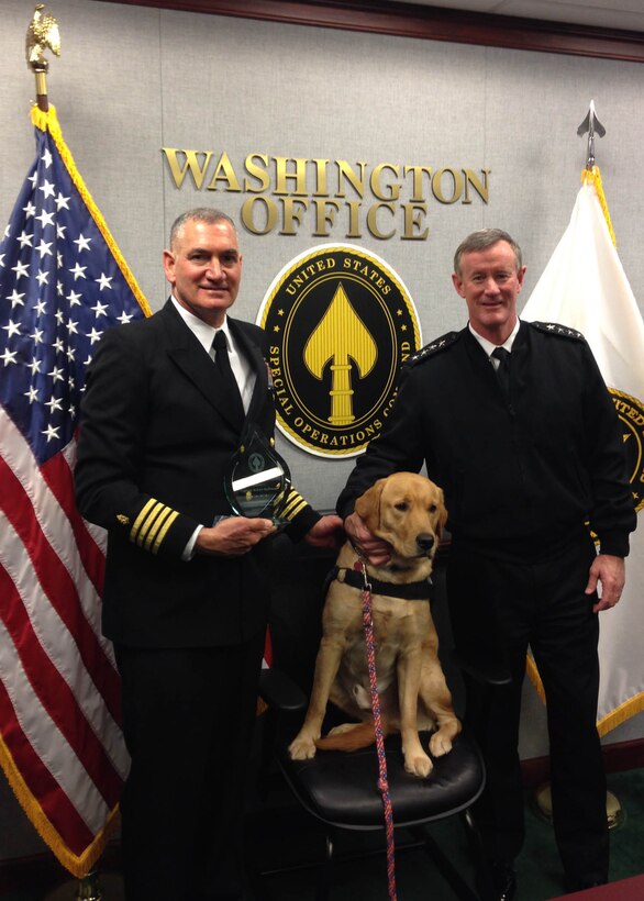Navy Capt. (Dr.) Robert Koffman, left, senior consultant for integrative medicine and behavioral health at the National Intrepid Center of Excellence in Bethesda, Md., accepts the U.S. Special Operations Command Patriot Award from Navy Adm. William H. McRaven, Socom’s commander, in a recent ceremony at the Pentagon. Koffman’s therapy dog, Ron, is the Navy psychiatrist’s “right-hand dog” when treating service member patients. Ron is trained to perform a multitude of therapeutic tasks, from fetching tissues for patients to laying his head in their laps when he senses they need comforting. Courtesy photo