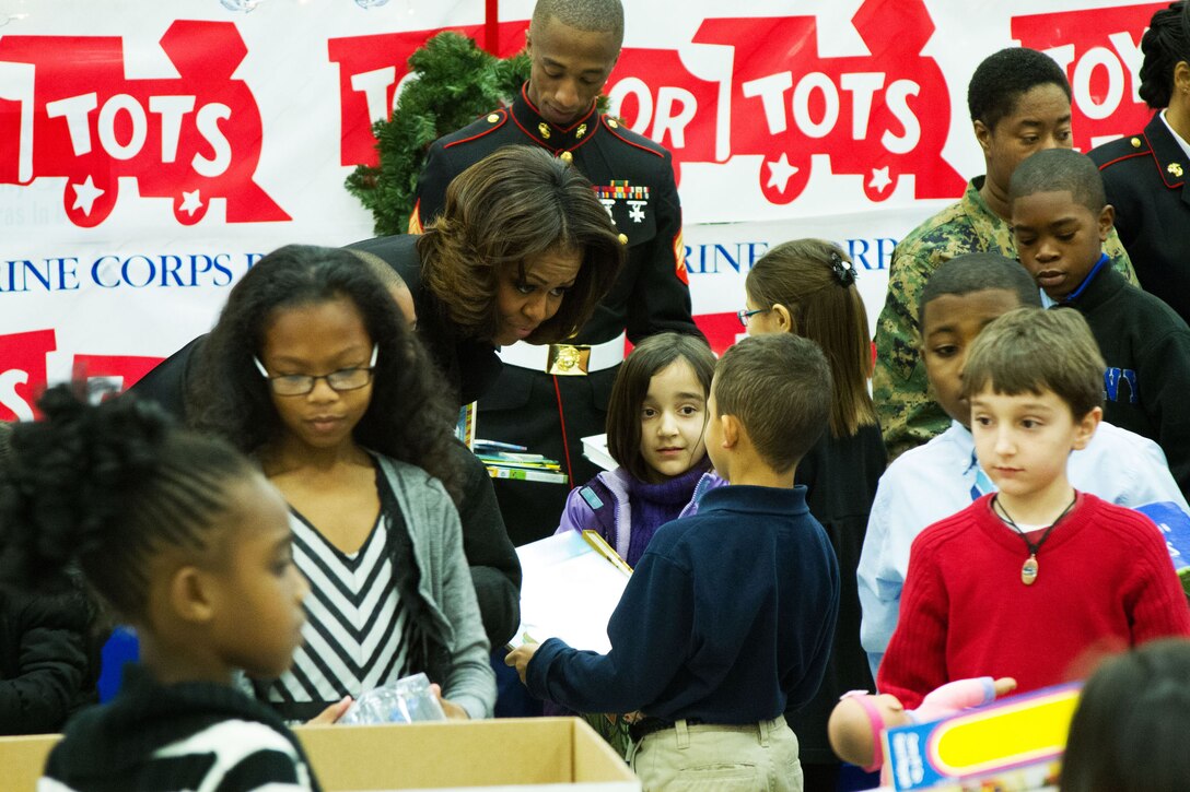 First Lady Michelle Obama helps young military dependents sort donated toys into age-appropriate groups during a Toys for Tots event on Joint Base Anacostia-Bolling in Washington, D.C., Dec. 19, 2013.