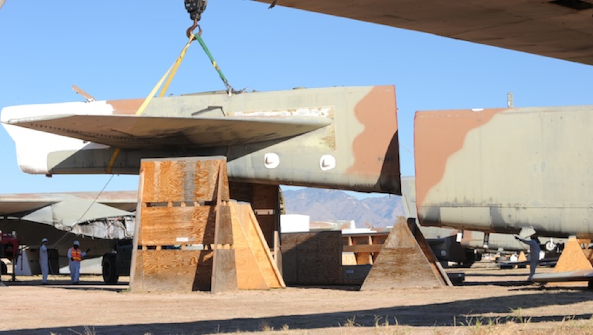 Personnel with the 578th Storage and Disposal Squadron lift a B-52G's tail section onto a custom-made cradle Dec, 19, 2013, at the 309th Aerospace Maintenance and Regeneration Group, Davis-Monthan Air Force Base, Ariz. The cradle is purposely placed 30 degrees off center and a minimum of six feet apart from the aircraft's fuselage in order for Russia's satellites to verify the elimination. (U.S Air Force photo/Staff Sgt. Angela Ruiz)