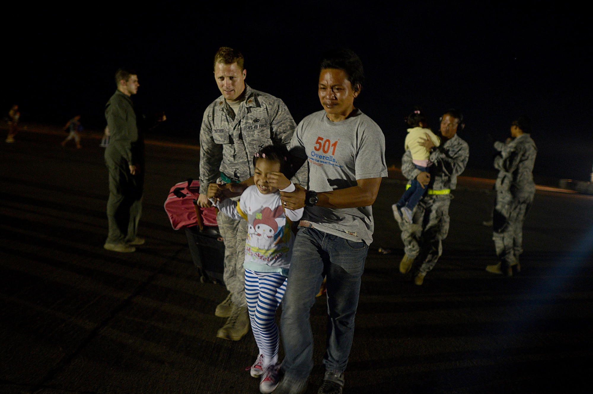 Maj. Dennis Trutwin, 736th Security Force Squadron commander, assists passengers as they board a U.S. Air Force C-130 Hercules in Tacloban, Philippines, during Operation Damayan Nov. 18, 2013. Operation Damayan is a humanitarian aid and disaster relief operation led by the Philippine government and supported by a multinational response force. (U.S. Air Force photo by 2nd Lt. Jake Bailey/Released)