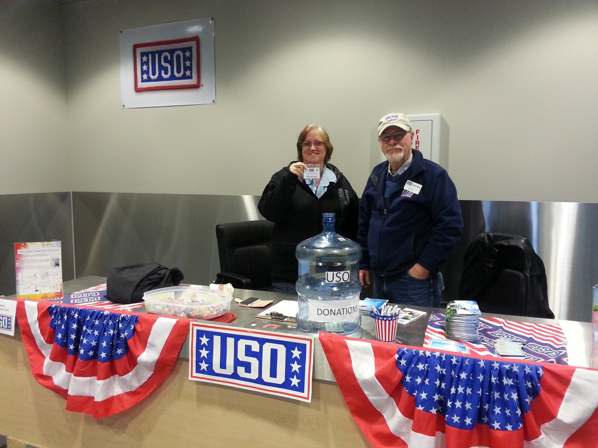 Ellen Jenkins and Ralph Nelson, United Service Organizations representatives, wait to greet incoming passengers in the 731st Air Mobility Squadron passenger terminal at Osan Air Base, Republic of Korea, Oct. 31, 2013. The USO and the 731st AMS have been in a unified partnership to support personnel as they transition in and out of the ROK since October 2012. (U.S. Air Force courtesy photo)