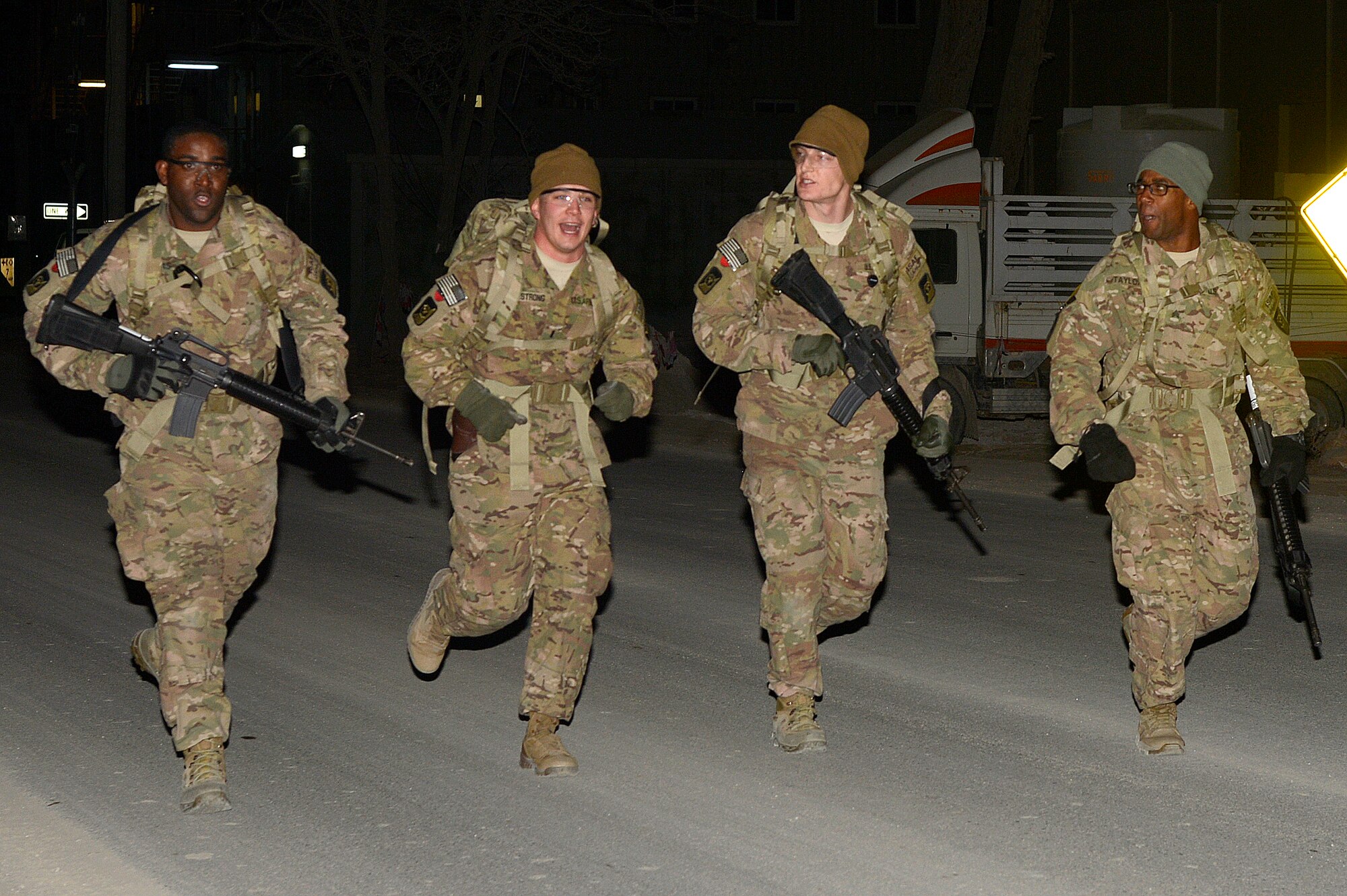 Service members run during the Sexual Assault Prevention and Response Dignity and Respect 5K Ruck March at Bagram Airfield, Afghanistan, Dec. 21, 2013. The first of the 21 teams completed the ruck march in 34 minutes and 49 seconds. (U.S. Air Force photo by Senior Airman Kayla Newman/Released)
