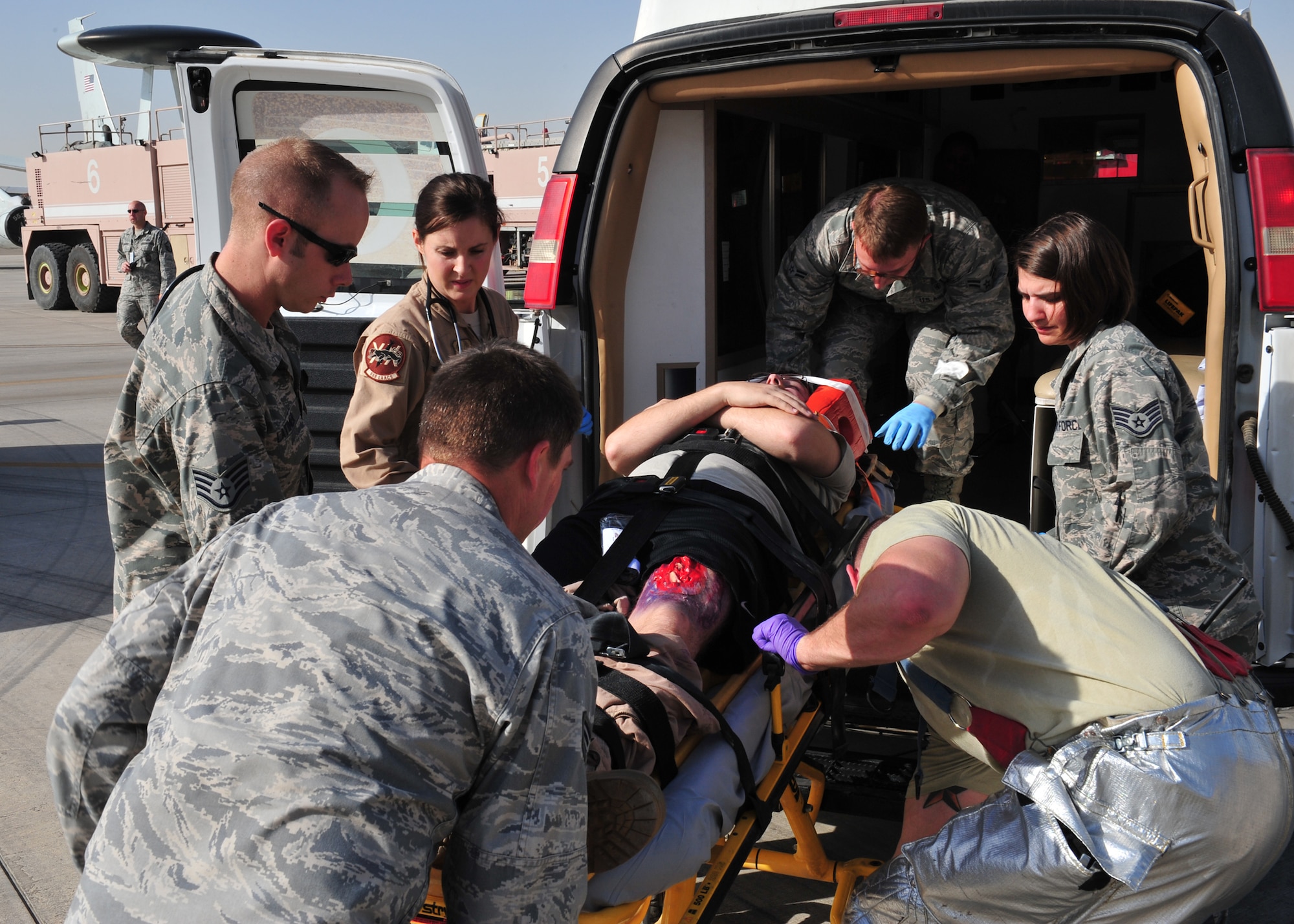 Medics, who are assigned to the 380th Expeditionary Medical Group here, treat a moulage victim with a chest wound during a Major Accident Response Exercise at an undisclosed location in Southwest Asia, Dec. 19, 2013. The MARE was held to ensure members of the wing can appropriately respond to a major accident. (U.S. Air Force photo by Staff Sgt. Michael Means/Released)