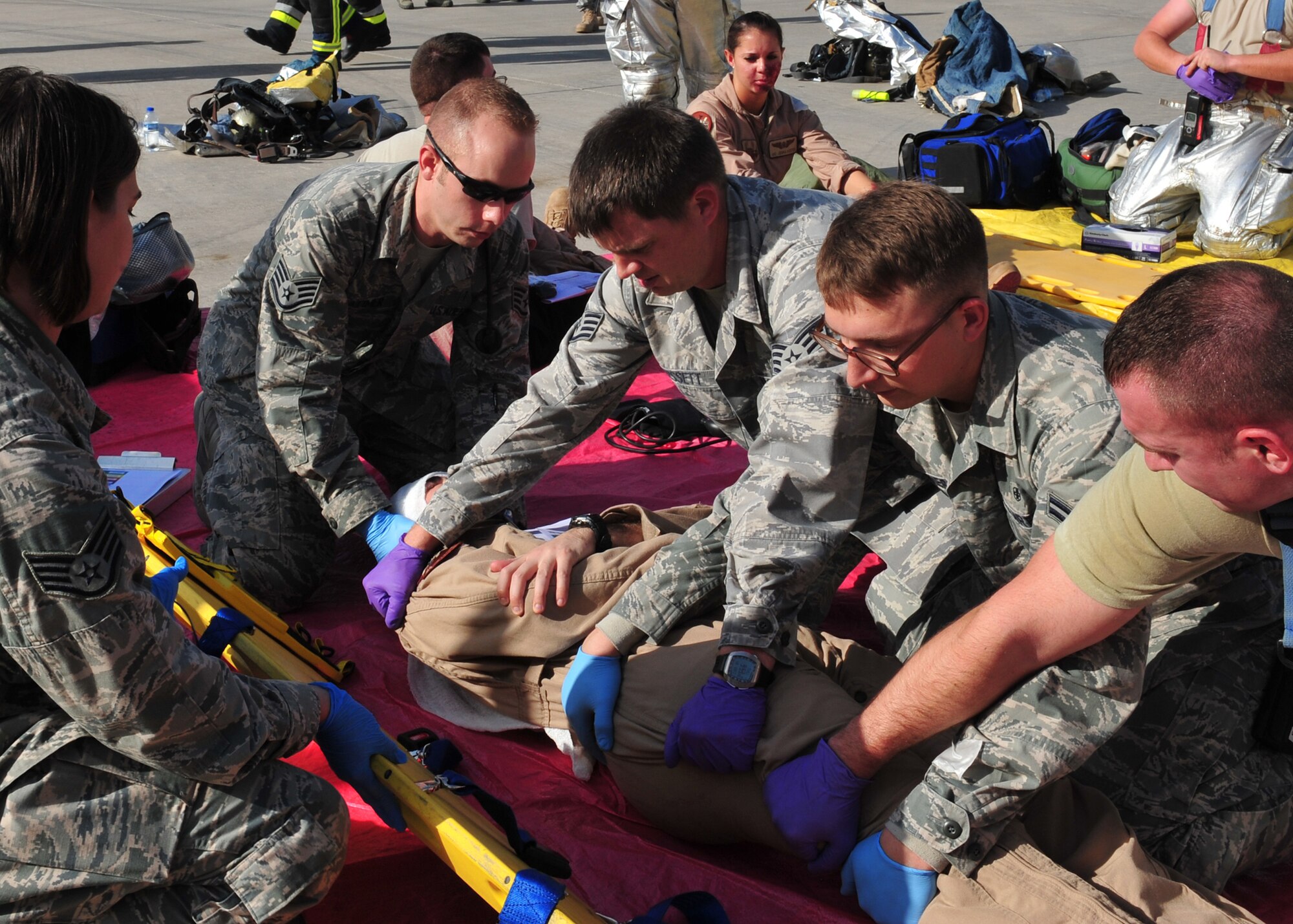Medics, who are assigned to the 380th Expeditionary Medical Group here, load a moulage victim on a litter during a Major Accident Response Exercise at an undisclosed location in Southwest Asia, Dec. 19, 2013. The MARE was held to ensure members of the wing can appropriately respond to a major accident. (U.S. Air Force photo by Staff Sgt. Michael Means/Released)