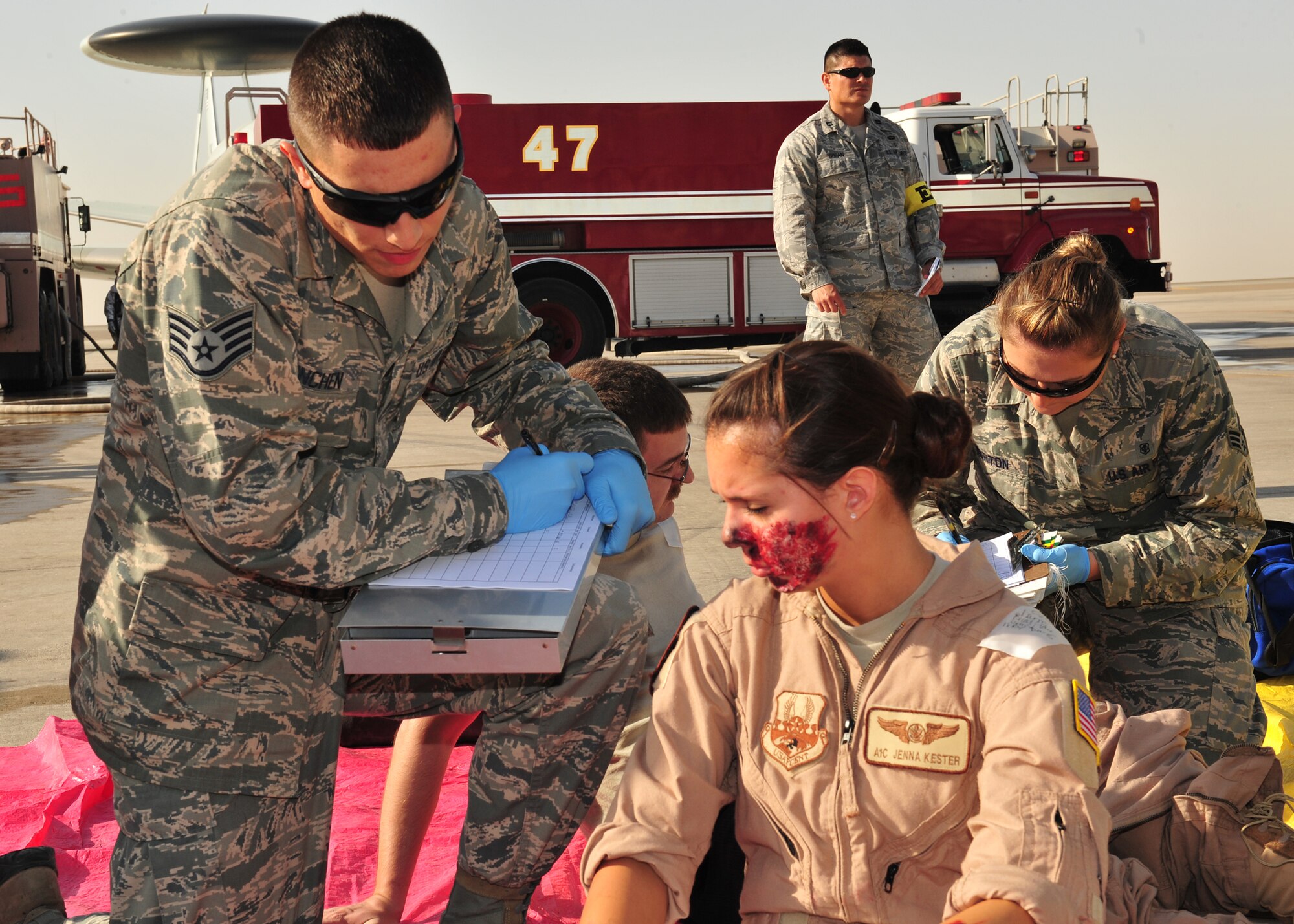 Air Force Staff Sgt. Randall Kinchen, 380th Expeditionary Medical Group medic, triages a victim during a Major Accident Response Exercise played by Airman 1st Class Jenna Kester, an airborne radar technician assigned to the 968th Expeditionary Airborne Air Control Squadron, at an undisclosed location in Southwest Asia, Dec. 19, 2013. The MARE is to ensure members of the wing can appropriately respond to a major accident. (U.S. Air Force photo by Staff Sgt. Michael Means/Released)