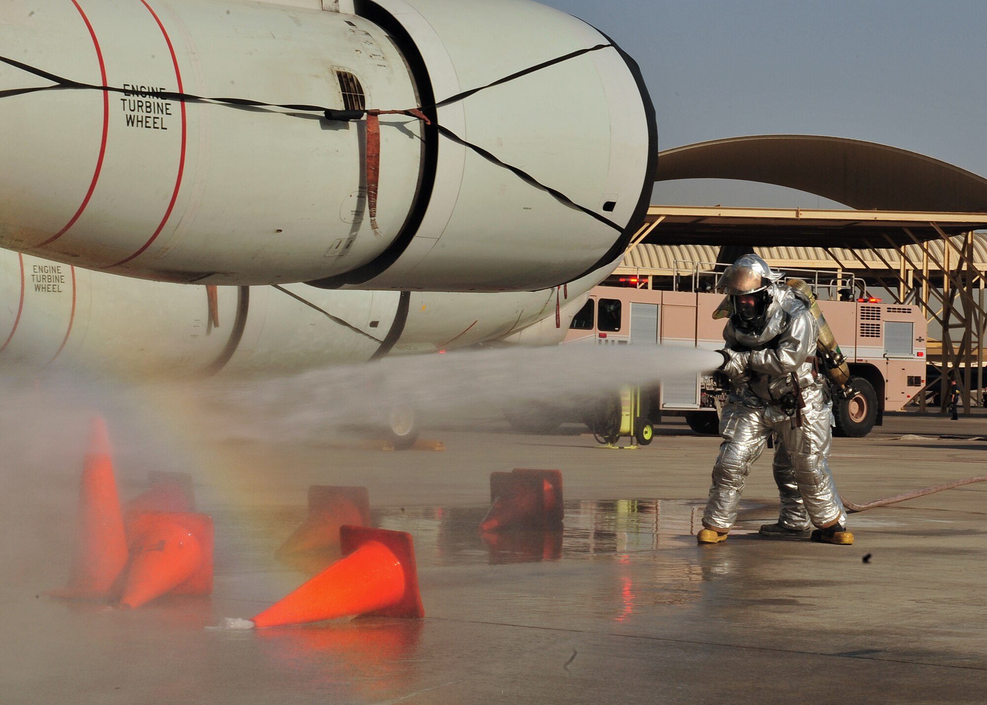 Firefighters, who are assigned to the 380th Expeditionary Civil Engineer Squadron here, put out a simulated fire during a Major Accident Response Exercise at an undisclosed location in Southwest Asia, Dec. 19, 2013. The MARE is to ensure members of the wing can appropriately respond to a major accident. (U.S. Air Force photo by Staff Sgt. Michael Means/Released)