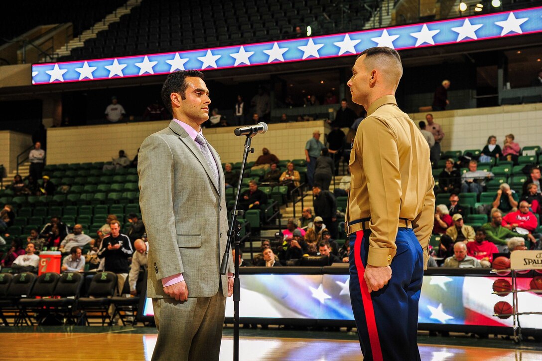 U.S. Marine Corps Capt. Nathan Harmon, Recruiting Station Detroit’s Officer Selection Officer, administers the oath of enlistment to Shane Azizi during half time at Eastern Michigan University men's basketball game against the University of Massachusetts Dec. 3, 2013. Azizi was one of 38 individuals selected for a reserve contract, and he is slated to attend Officer Candidates School January 2014. (U.S. Marine Corps photo by Sgt. Elyssa Quesada/Released)