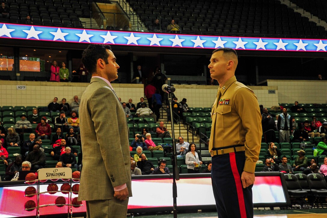 U.S. Marine Corps Capt. Nathan Harmon, Recruiting Station Detroit’s Officer Selection Officer, administers the oath of enlistment to Shane Azizi during half time at Eastern Michigan University men's basketball game against the University of Massachusetts Dec. 3, 2013. Azizi was one of 38 individuals selected for a reserve contract, and he is slated to attend Officer Candidates School January 2014. (U.S. Marine Corps photo by Sgt. Elyssa Quesada/Released)