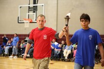 A Special Olympics athlete along with a Marine from the Wounded Warrior Battalion, carry in the torch signifying the start of the games. Marine Corps Air Station New River, in partnership with Special Olympics Onslow County hosted the 14th annual Special Olympics Fall Games at the AS-4400 fitness center, Dec. 6.
