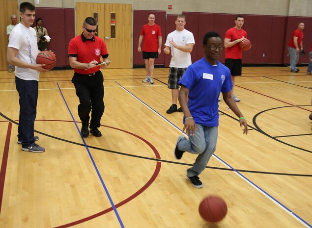 A Special Olympics athlete dribbles a basketball down a designated area on the court while being timed to see how many points he can rack up toward his score. Marine Corps Air Station New River, in partnership with Special Olympics Onslow County hosted the 14th annual Special Olympics Fall Games at the AS-4400 fitness center, Dec. 6.
