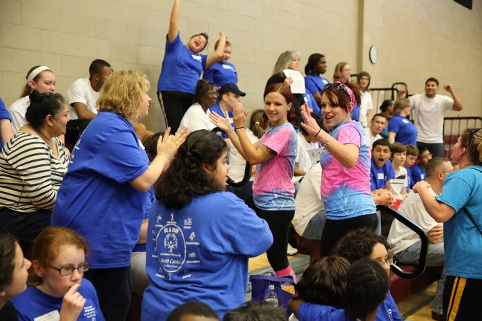 A group of volunteers entertain the awaiting Special Olympics athletes while they wait their turn to partake in the games. Marine Corps Air Station New River, in partnership with Special Olympics Onslow County hosted the 14th annual Special Olympics Fall Games at the AS-4400 fitness center, Dec. 6.
