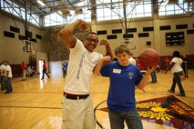 A Special Olympics Athlete and his accompanying volunteer pose for a picture and flex their guns after an impressive basketball shooting display. Marine Corps Air Station New River, in partnership with Special Olympics Onslow County hosted the 14th annual Special Olympics Fall Games at the AS-4400 fitness center, Dec. 6.
