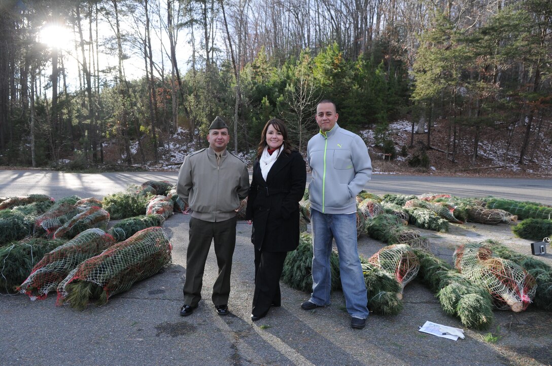 From left, Gunnery Sgt. Guy Saucedo, operations chief for Quantico’s Logistics Division; Stephanie Taber, the installation family readiness officer; and Staff Sgt. Juan Jimenez, deputy family readiness officer for the Wounded Warrior Regiment, distribute donated Christmas trees in the afternoon of Dec. 13, 2013. 