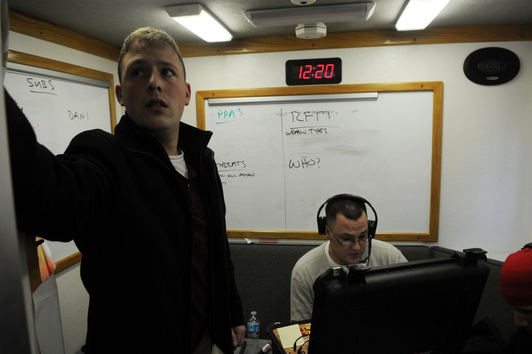 In a cramped room in a mobile command unit, Sgt. Colin Kelley negotiates remotely with a woman who’s taken a bank hostage while Sgt. Evan Baschnagel jots notes on a whiteboard about the details of the situation. Both are Criminal Investigation Division Marines. The scenario was one of four being played out Dec. 13, 2013, during the culmination of a week of crisis negotiation training offered by the FBI. 