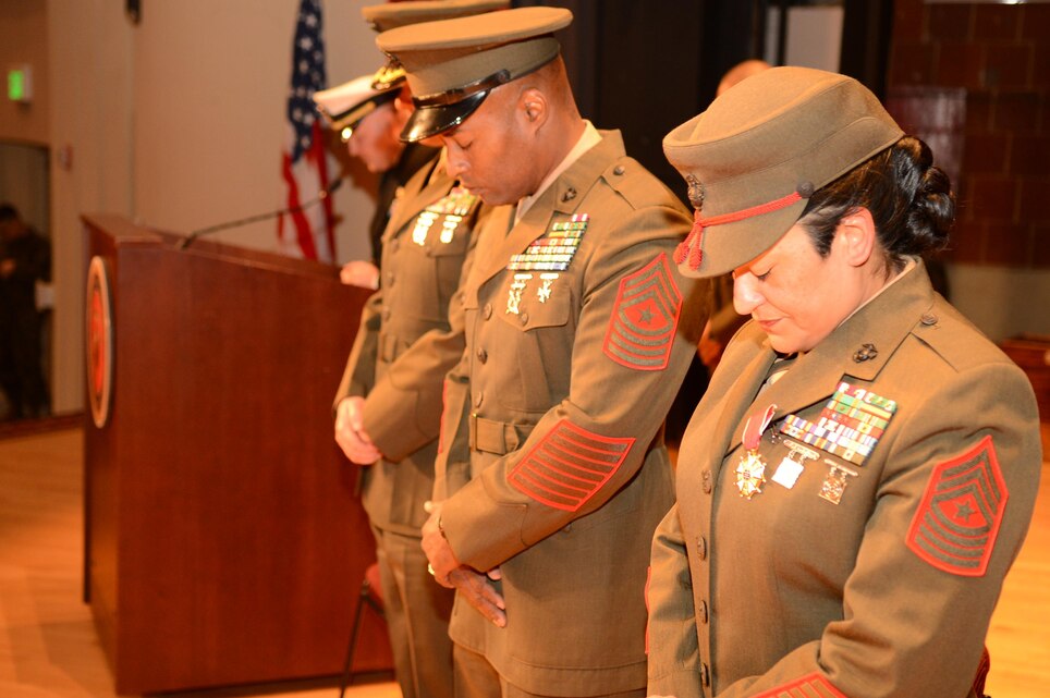 Sgt. Maj. Mark Byrd, the new sergeant major of Marine Corps Base Quantico, left, and Sgt. Maj. Laura Brown, the base’s outgoing sergeant major, bow their heads during the invocation at the relief and appointment ceremony where they handed off the sword of office on Dec. 18, 2013, at Little Hall. 