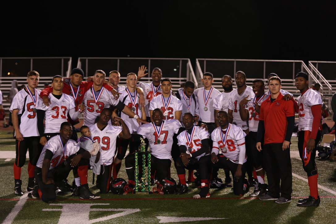Players from the Marine Corps Air Station Miramar Falcons football team, pose with their awards and trophy after the championship game at Paige Field House aboard Marine Corps Base Camp Pendleton, Nov. 19. The Falcons received a second place trophy, first place going to the 1st Radio Battalion FREQS.



