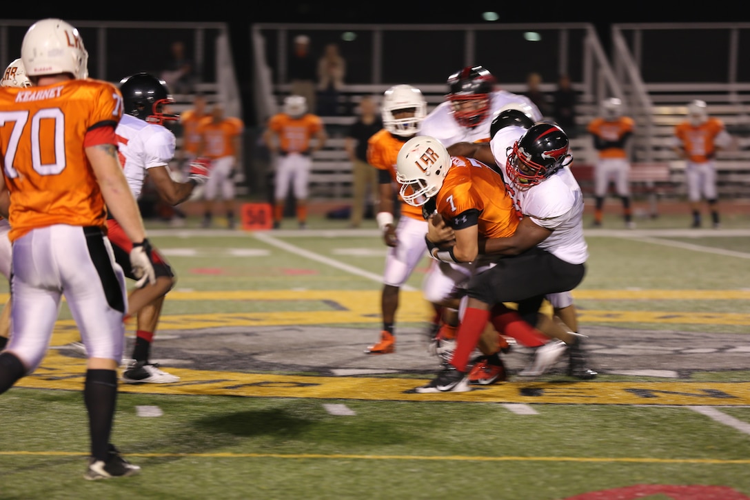 Michael Young, Falcons’ defensive lineman, drags a 1st Light Armored Reconnaissance Battalion Highlander running back to the ground at Paige Field House aboard Marine Corps Base Camp Pendleton, Calif., Nov. 12. The Falcons defense held the Highlanders to only six points during the 29-6 victory.


