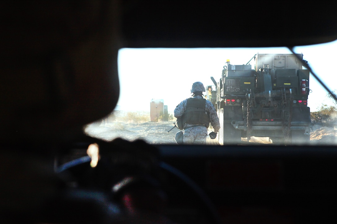 A Marine with 2nd Platoon, General Support Motor Transportation Company, Combat Logistics Regiment 1, 1st Marine Logistics Group, guides a Humvee before an immediate action drill on a routine convoy aboard Marine Corps Air Ground Combat Center Twentynine Palms, Calif., during Exercise Steel Knight 2014, Dec. 13. Marines received different scenarios before leaving on the convoy, keeping them on their toes by leaving little time to plan. SK14, which took place Dec. 9-16, is an annual exercise designed to prepare the 1st Marine Division for deployment with the Marine Air Ground Task Force as the Ground Combat Element with the support of 1st MLG and 3rd Marine Air Wing. Combined, the MAGTF is able to deploy and respond in a timely manner to any situation across the globe.