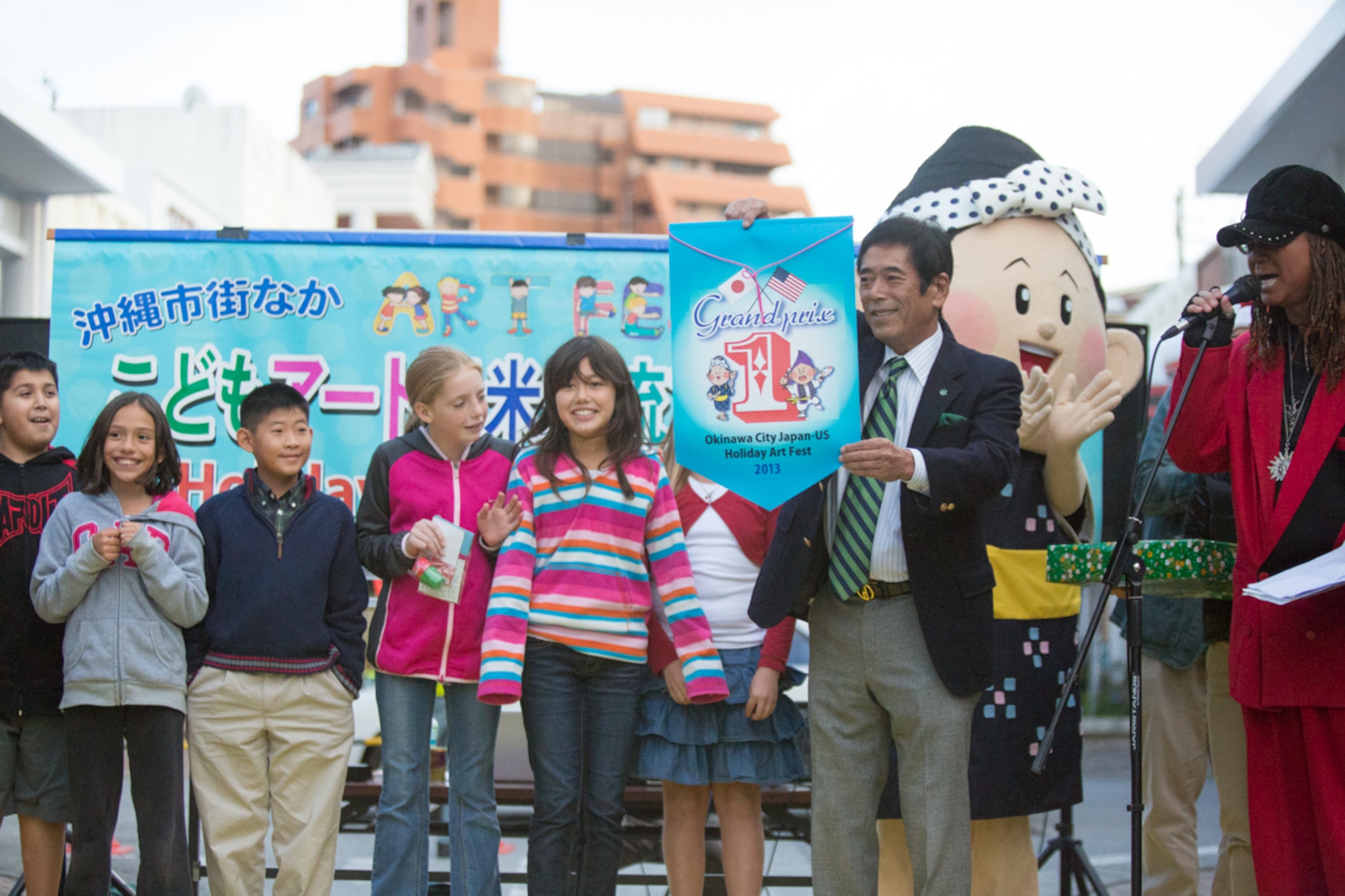Members of the Amelia Earhart Intermediate School art team from Kadena Air Base, Japan, receive an award for first place in the 2013 Okinawa City Japan-US Kids Holiday Art Fest Dec. 22. Twelve groups of children from Kadena, Bob Hope, and Stearley Heights Elementary Schools, Amelia Earhart Intermediate School, and Okinawa City schools painted holiday themed murals for the community project. (U.S. Air Force photo by Tech. Sgt. Steven Whitley)