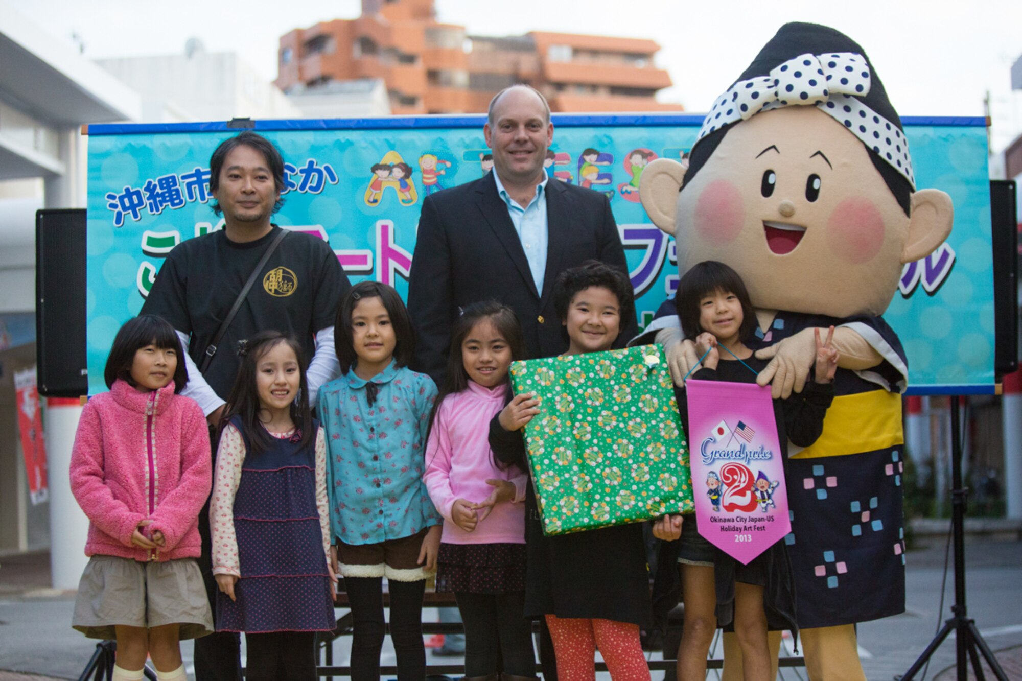 Members of the Moromi Elementary School art team from Okinawa City, Japan, receive an award for second place in the 2013 Okinawa City Japan-US Kids Holiday Art Fest Dec. 22. Twelve groups of children from Kadena, Bob Hope, and Stearley Heights Elementary Schools, Amelia Earhart Intermediate School, and Okinawa City schools painted holiday themed murals for the community project. (U.S. Air Force photo by Tech. Sgt. Steven Whitley)