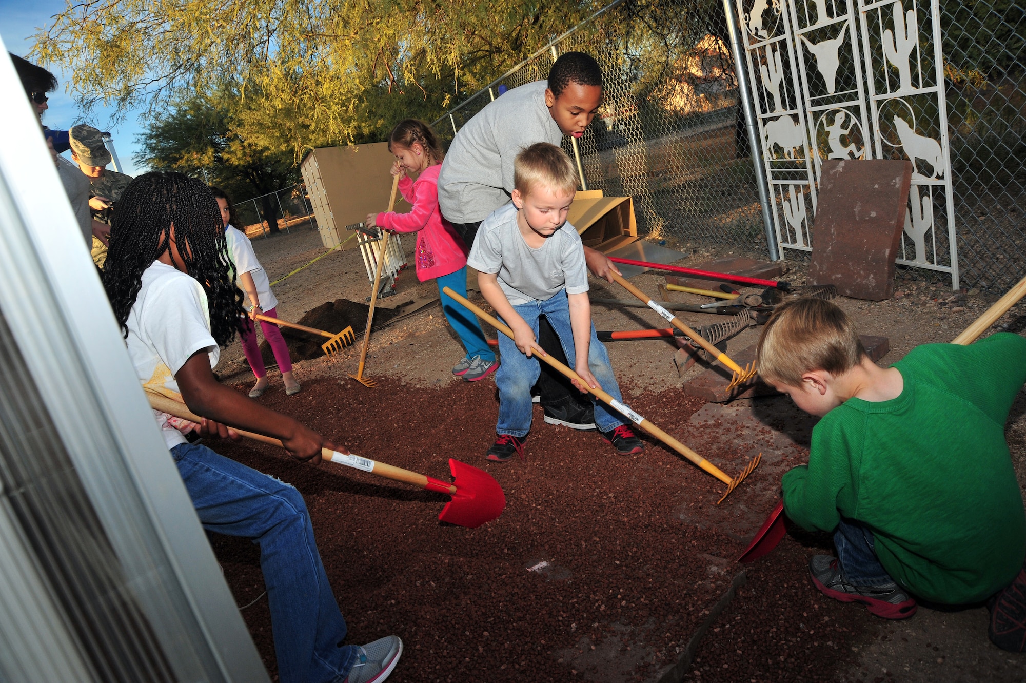 Children at the School Age Program dig up dirt at the center at Davis-Monthan Air Force Base, Ariz., Dec. 17, 2013. The greenhouse is a new, interactive facility that D-M has built for the School Age program, to teach the kids what a greenhouse is and how to plant, dig, and water plats properly. (U.S. Air Force photo by Airman 1st Class Betty R. Chevalier/Released)