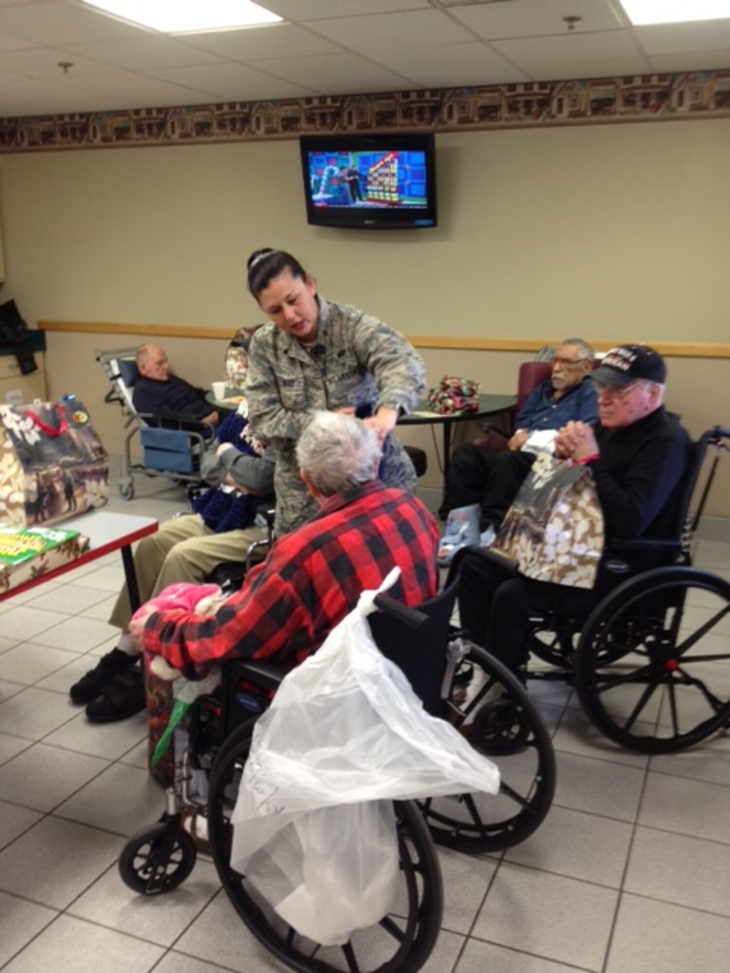 Major Lena Holliday, 507th Force Support Squadron passes out gifts to the veterans at the annual Norman Veterans Center Christmas party, Dec. 23. (U.S. Air Force Photo/1st Lt. Cristi Jordan)
