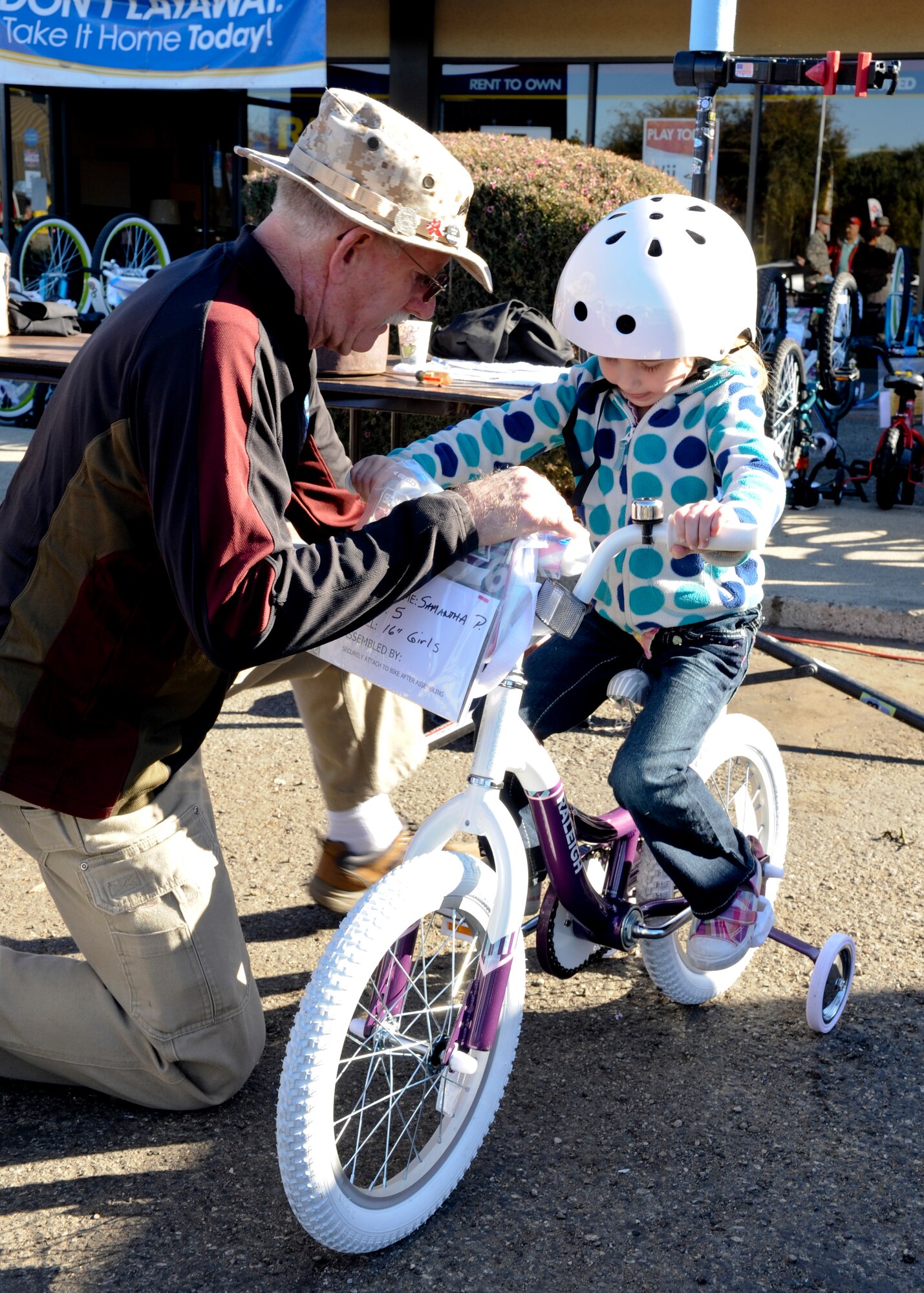LOMPOC, Calif. – A member of a local cycling group, The Village Dirtbags, adjusts a bicycle in Lompoc Saturday, Dec. 21, 2013. This event marked the 8th annual Christmas Bikes for Vandenberg Air Force Base military children. All bikes and helmets where purchased through Bicycle Unlimited for families with deployed spouses and single income families. (U.S. Air Force photo/ Airman 1st Class Yvonne Morales)